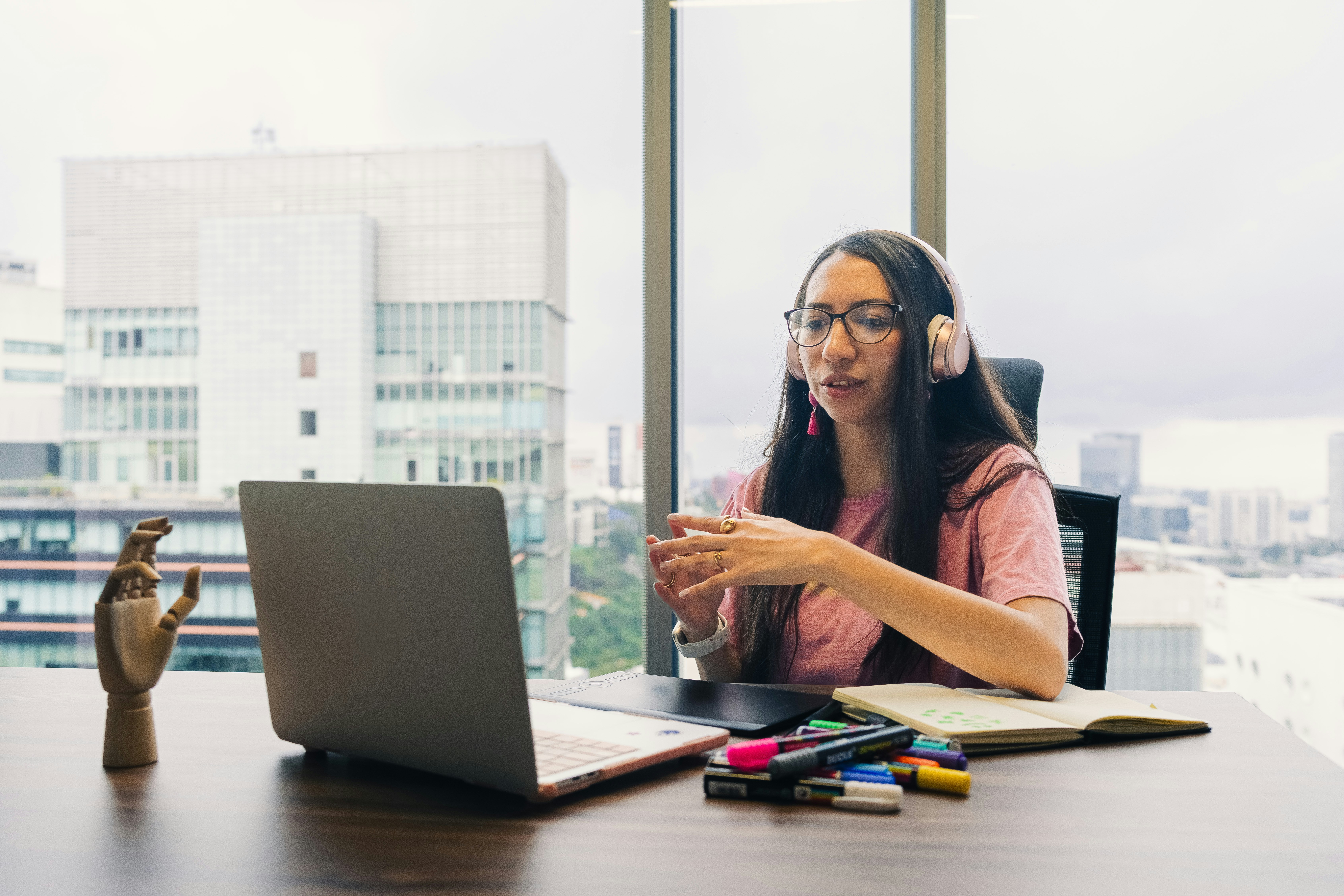 Woman wearing headphones talks during video call