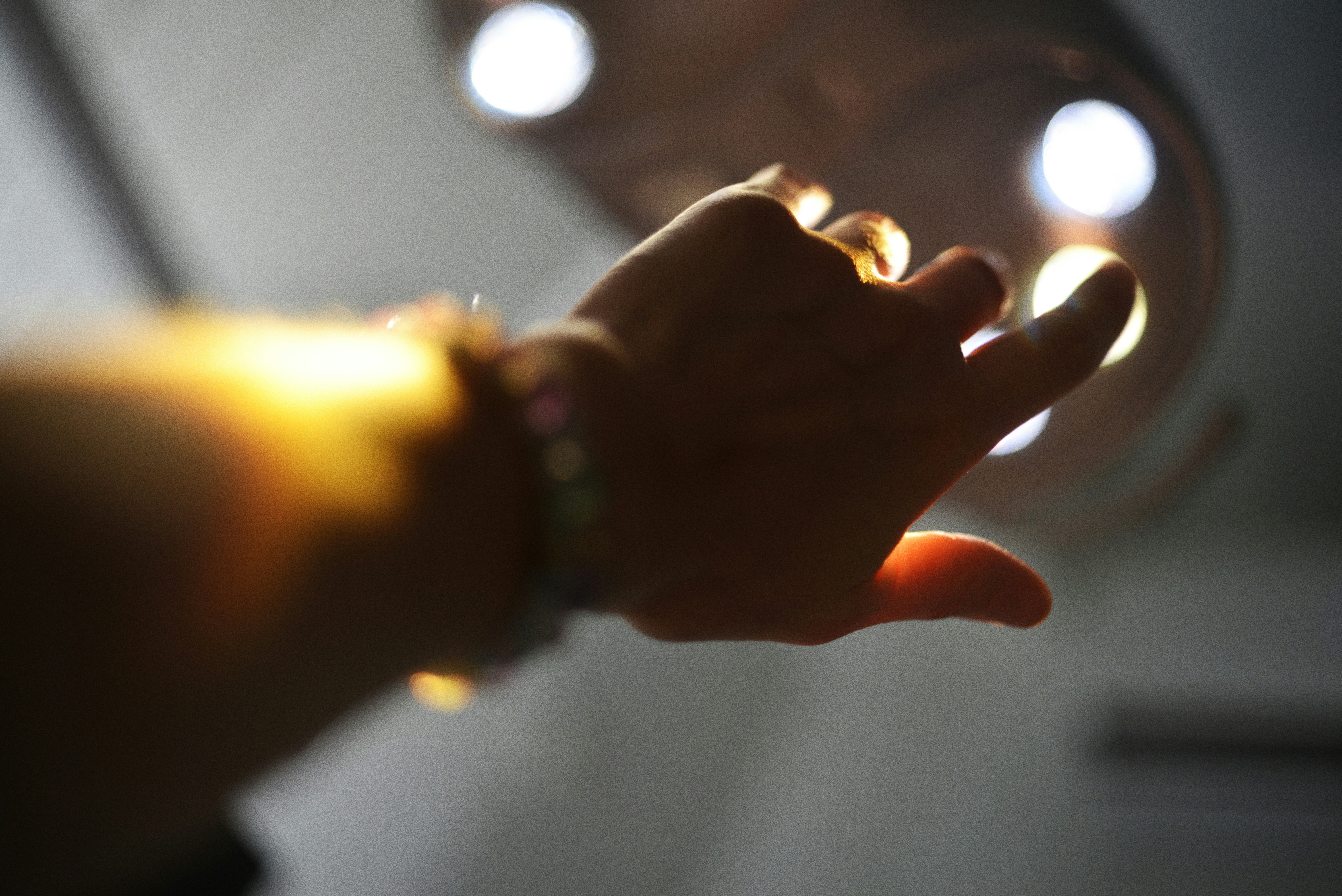 Hand reaching towards bright lights