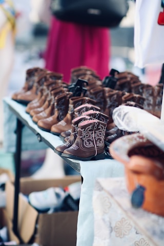 Rows of small brown cowboy boots displayed on a table.