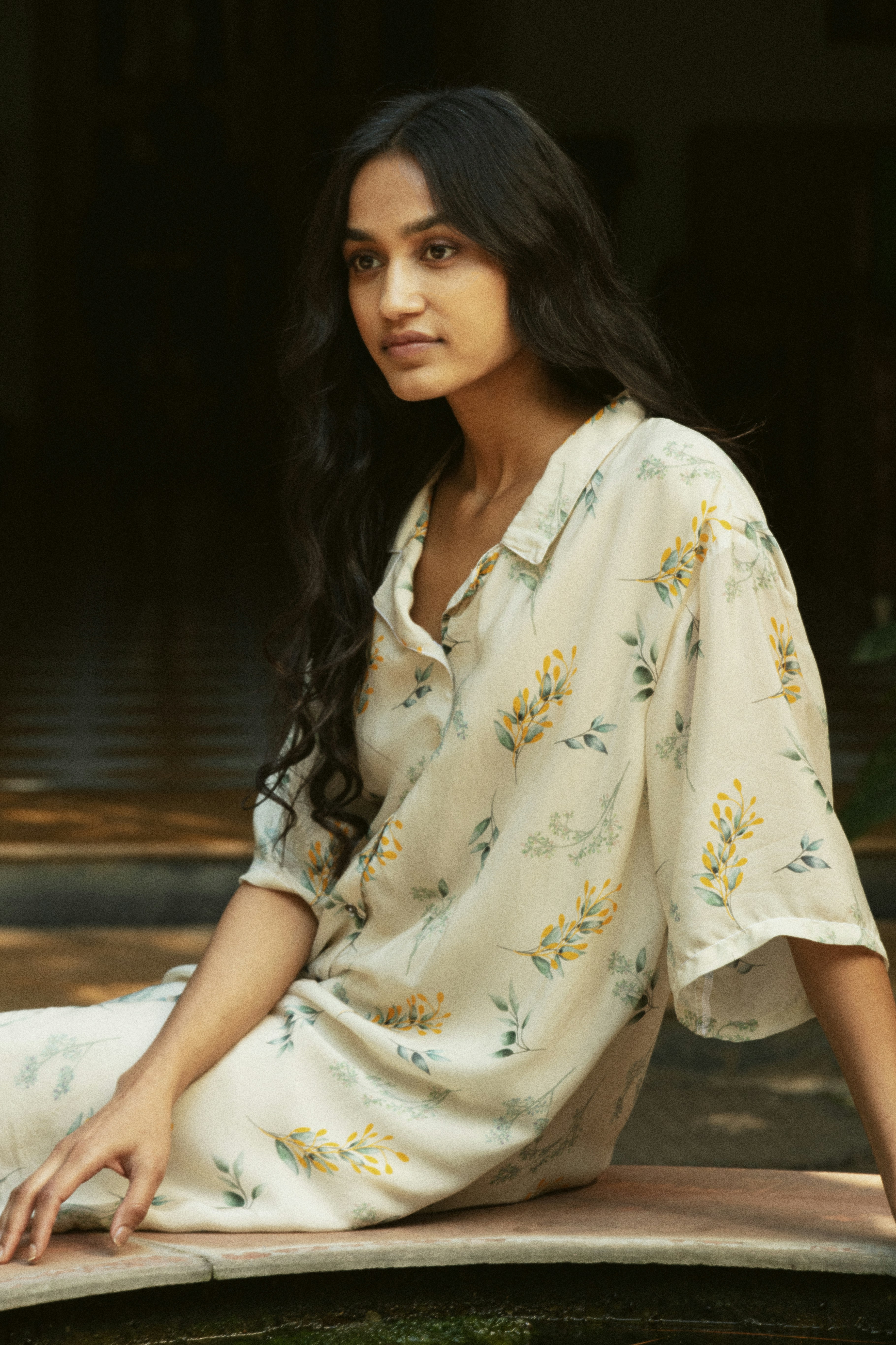 A woman wearing a floral print shirt outdoors.