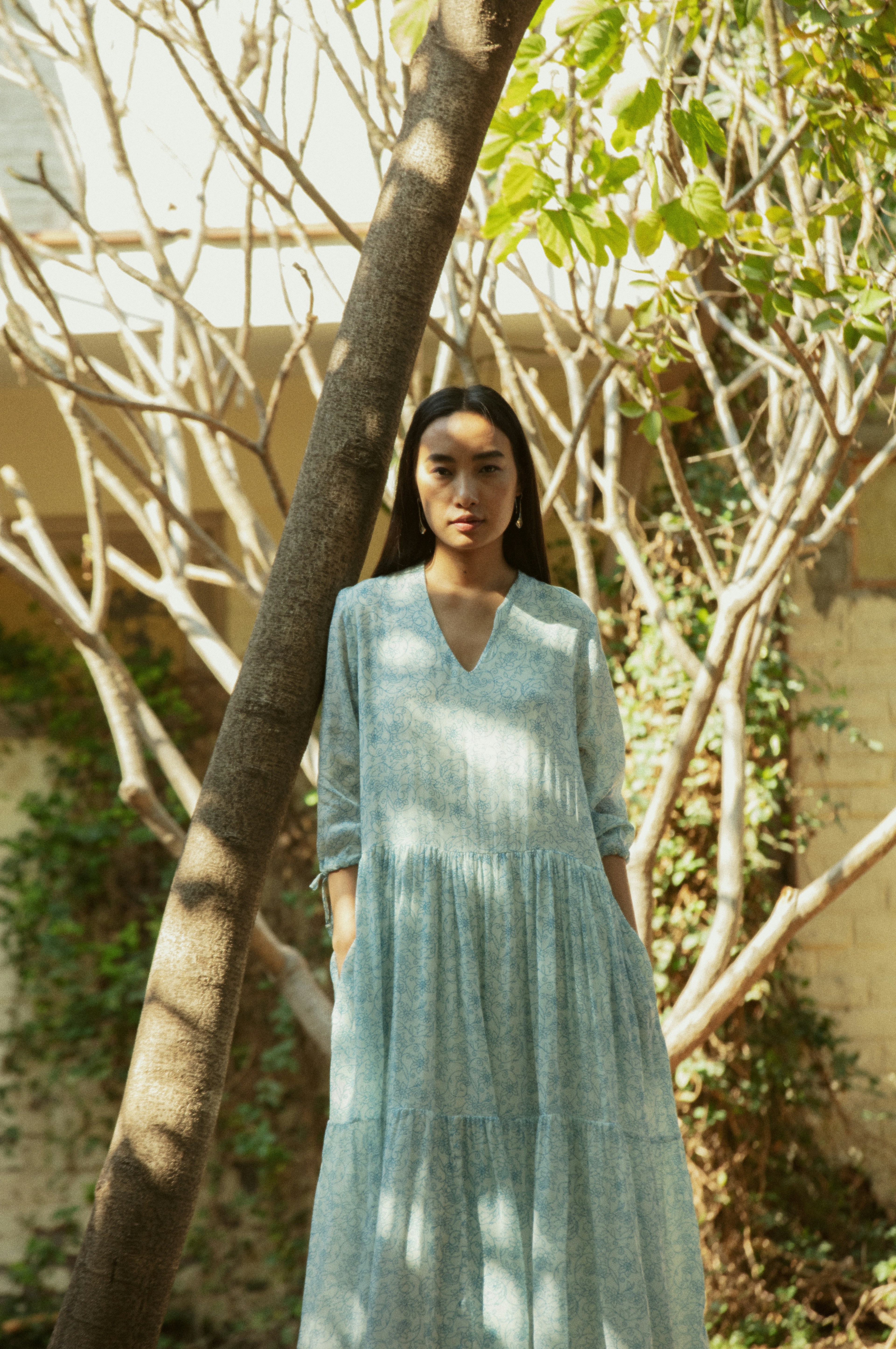 Woman in a light blue patterned dress outdoors