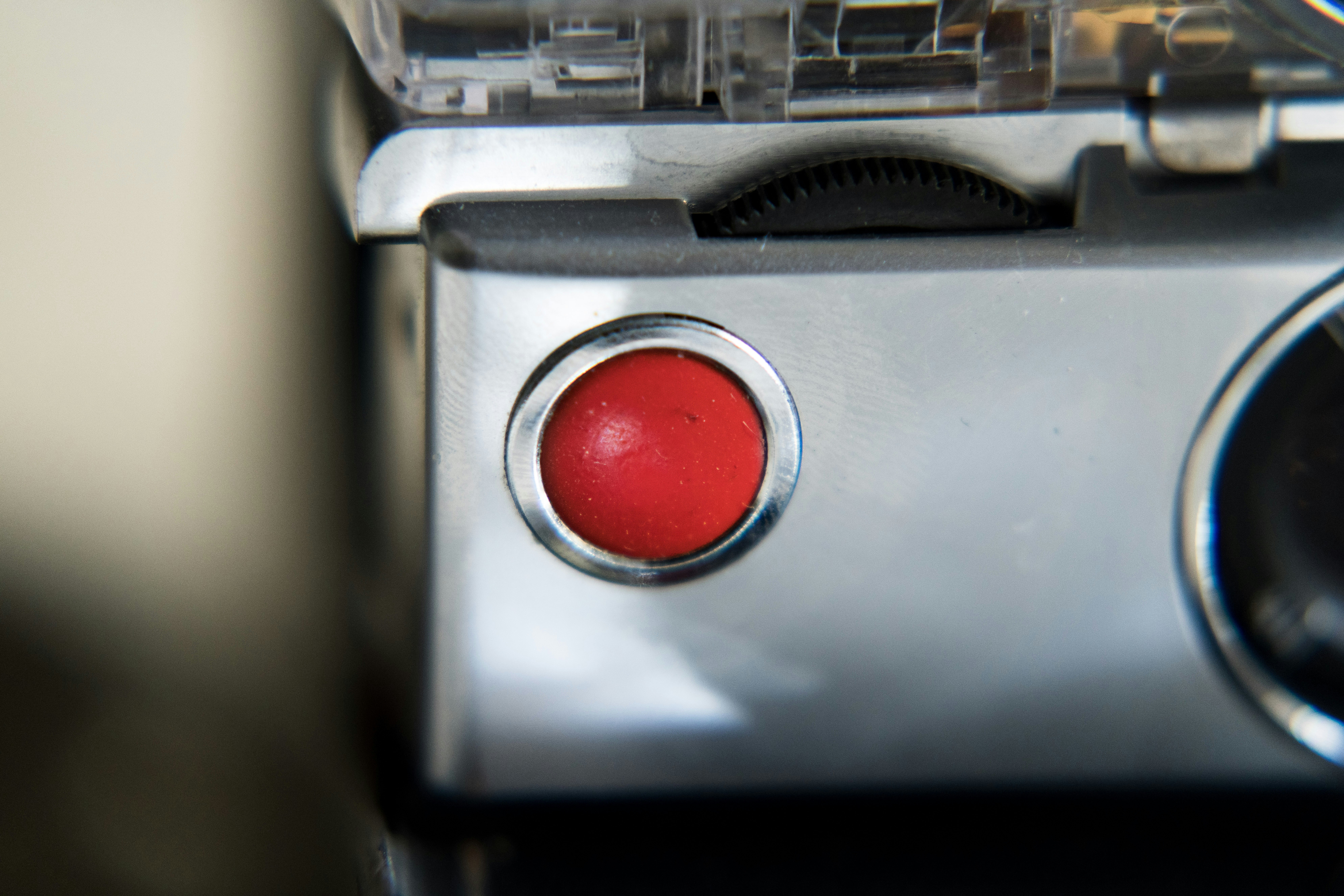 Close-up of a red button on a silver device.