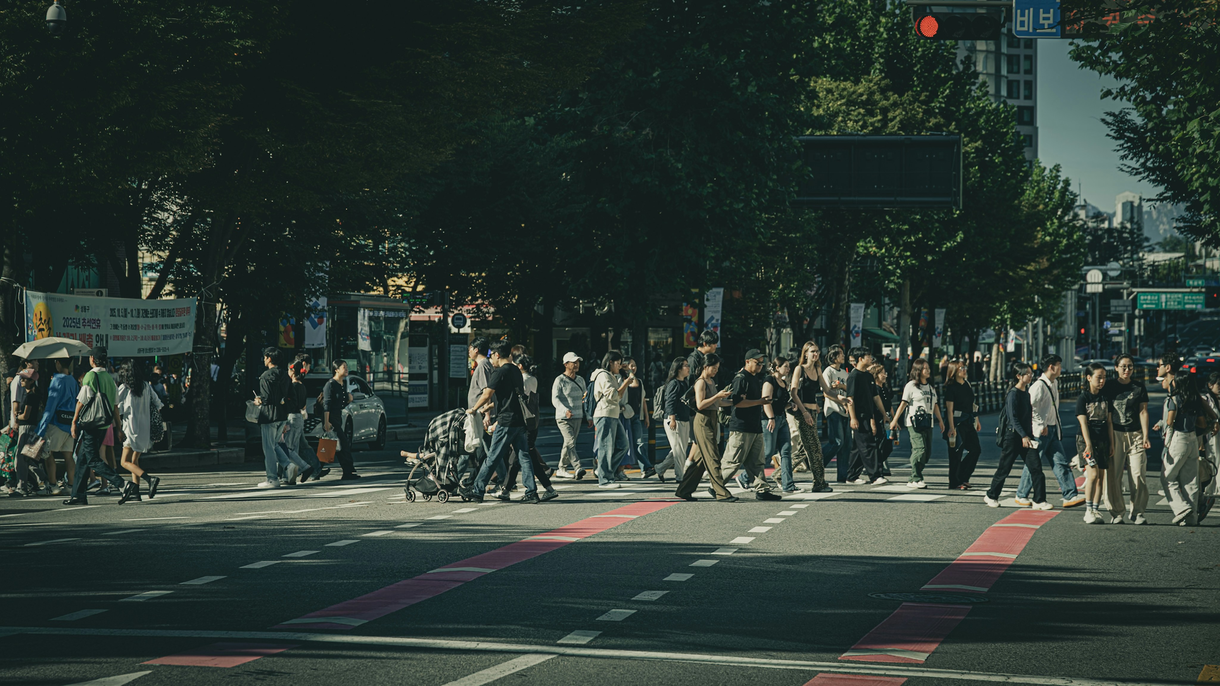 Crowd of people crossing a busy city street.