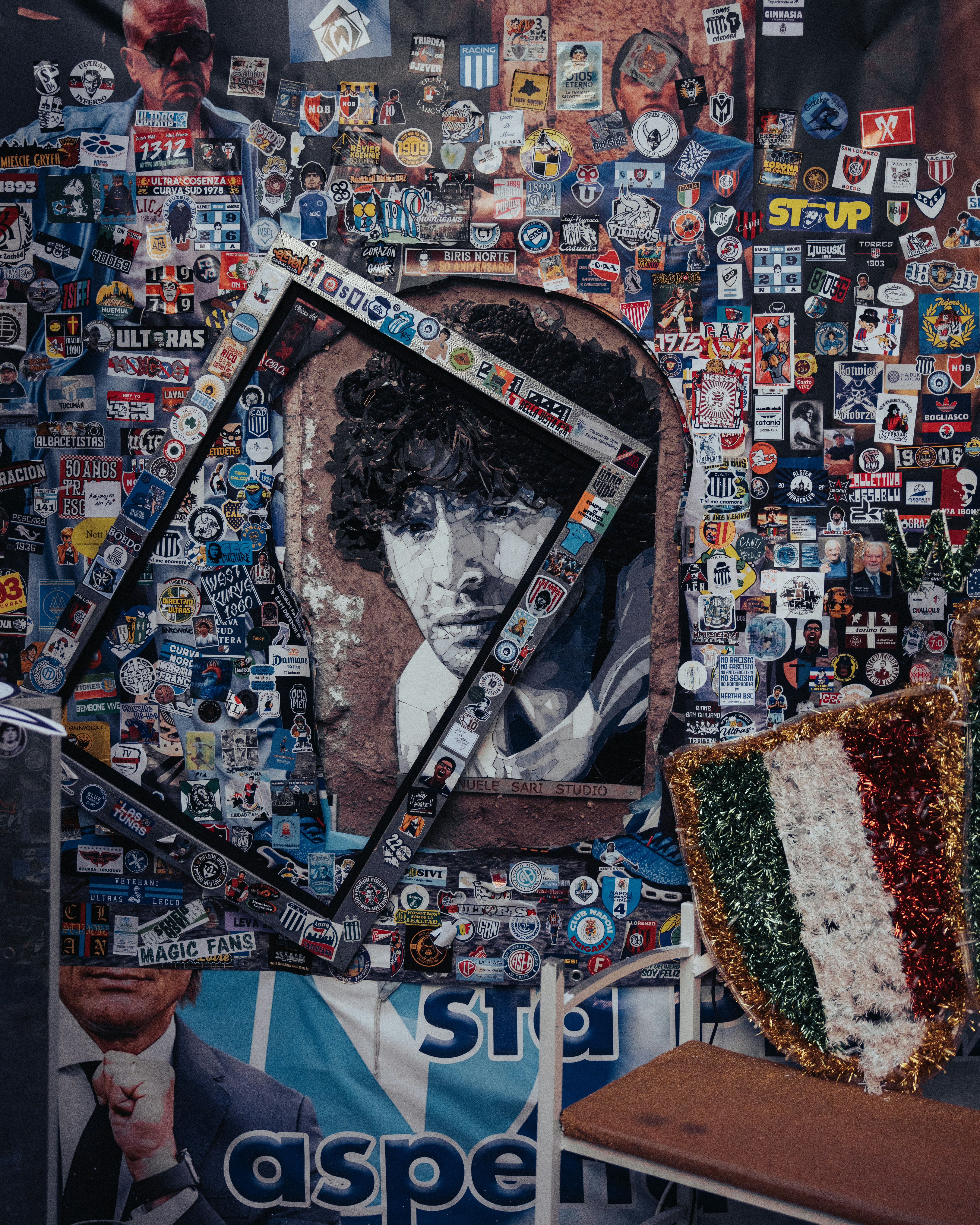 액자에 걸린 초상화가 있는 스티커로 덮인 벽.