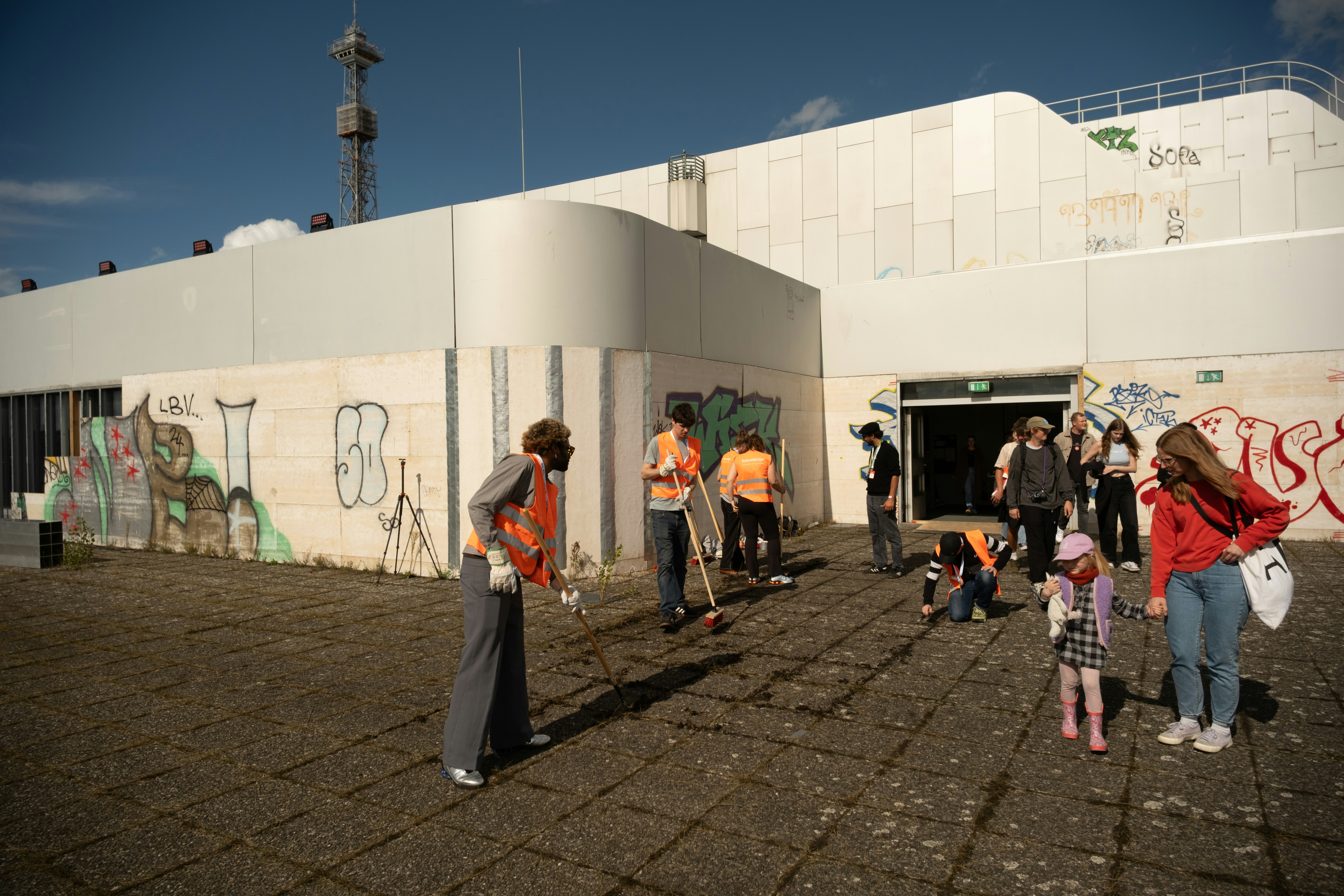 Group of people cleaning up graffiti outside building