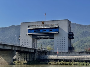 Modern building with bridge over river and mountains