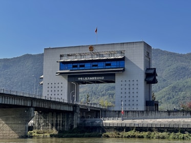Modern building with bridge over river and mountains