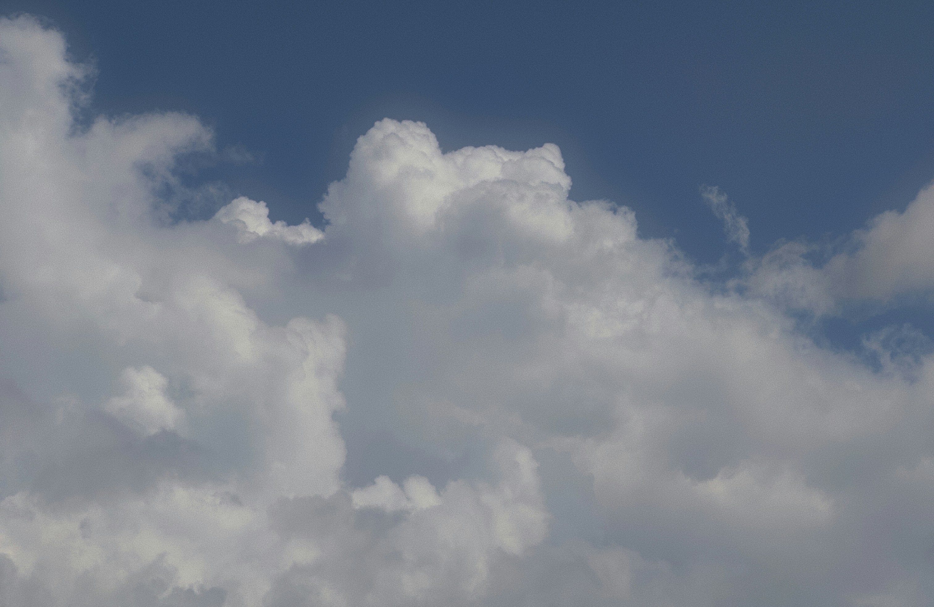 Fluffy white clouds against a clear blue sky