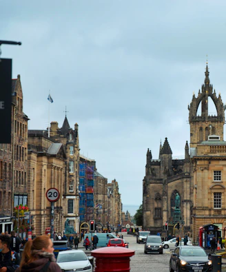 Street view of historic edinburgh buildings with cars.