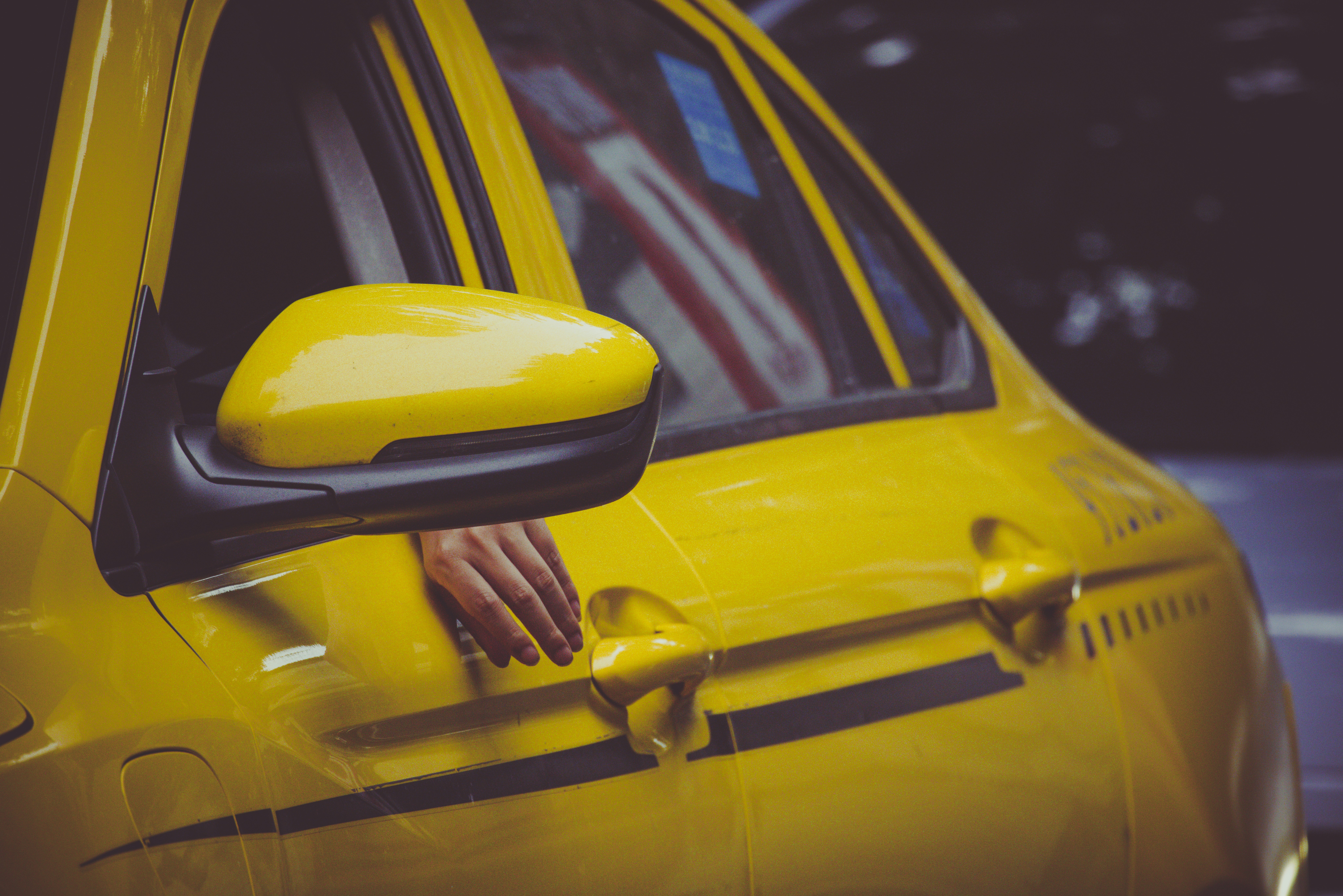 Yellow taxi cab with a hand reaching out