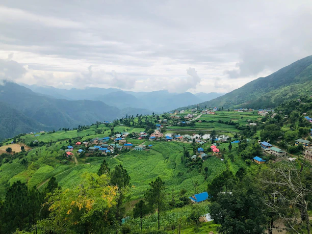 A village nestled in lush green rolling hills