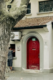 Man at a red door with building number 129