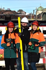 Three construction workers holding tools and level