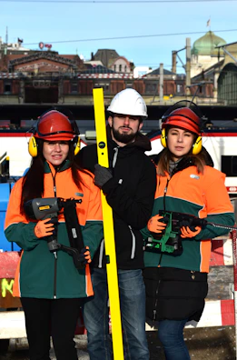 Three construction workers holding tools and level