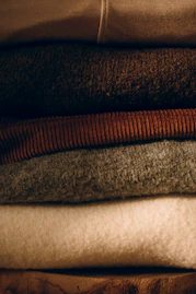 Stack of folded cozy sweaters in neutral colors
