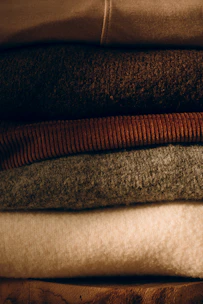 Stack of folded cozy sweaters in neutral colors