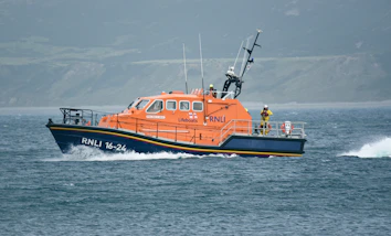 Orange lifeboat boat moving through choppy water
