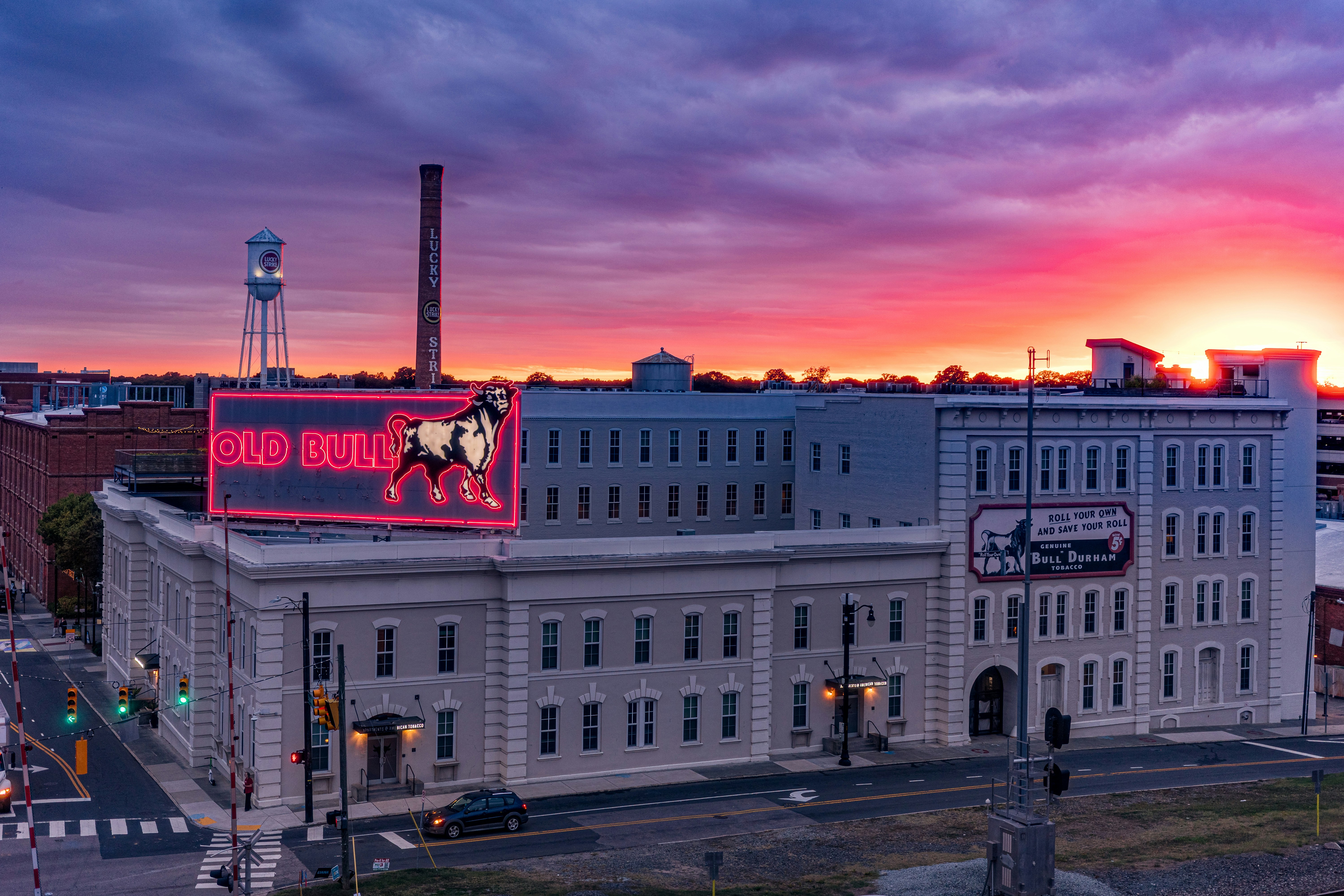 Historic building with neon sign at sunset