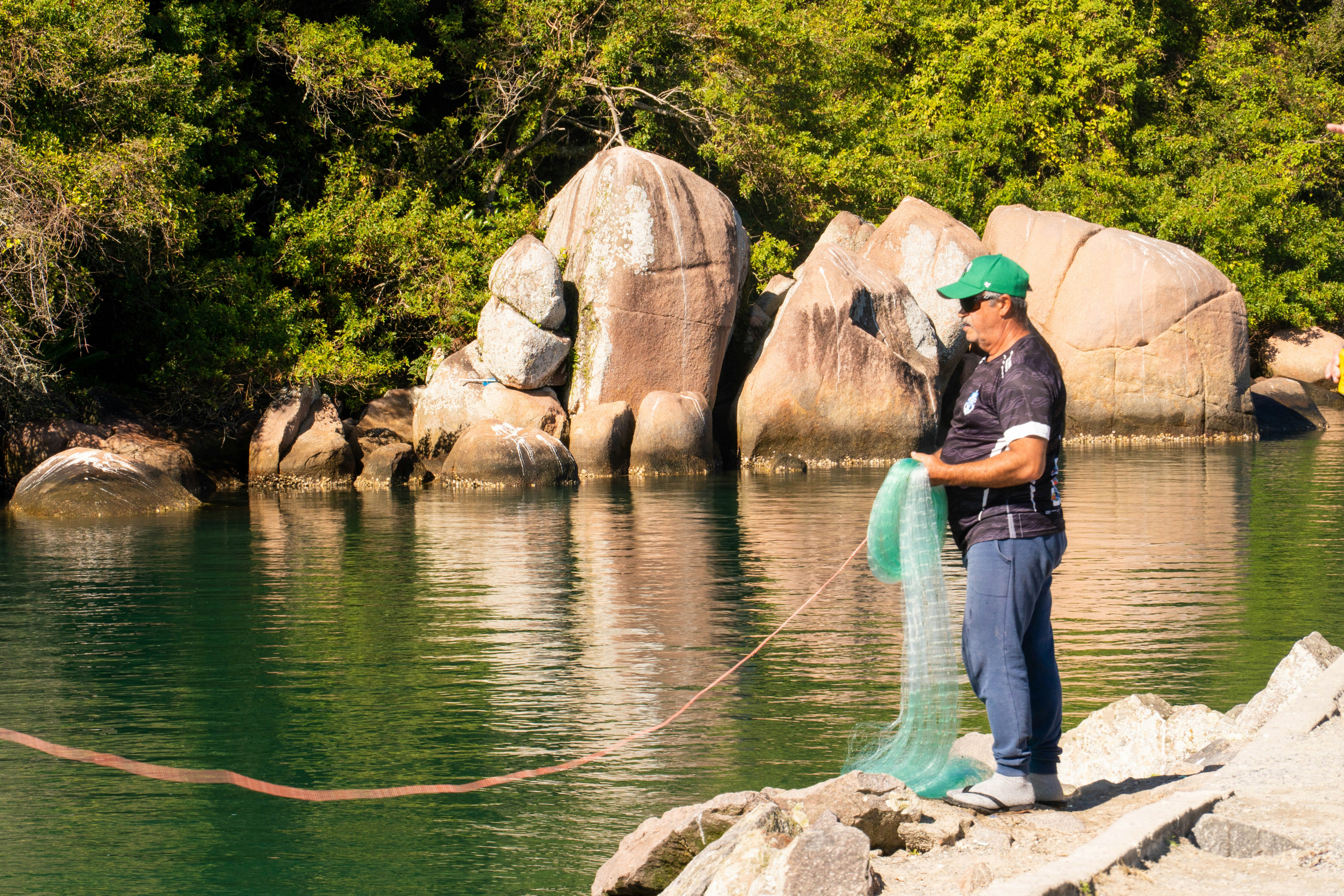 Man holding a fishing net by the water