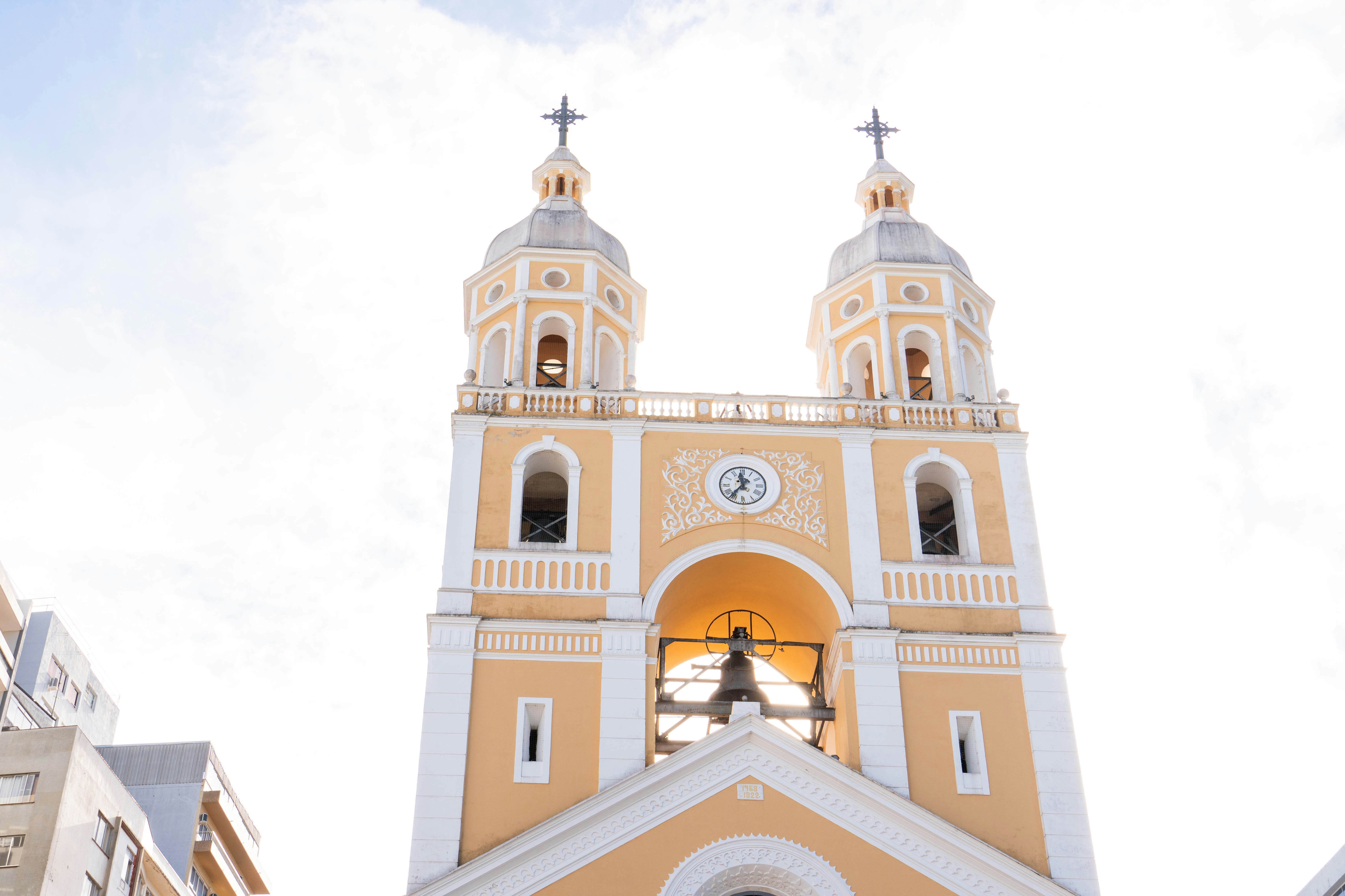A yellow church tower with two bells
