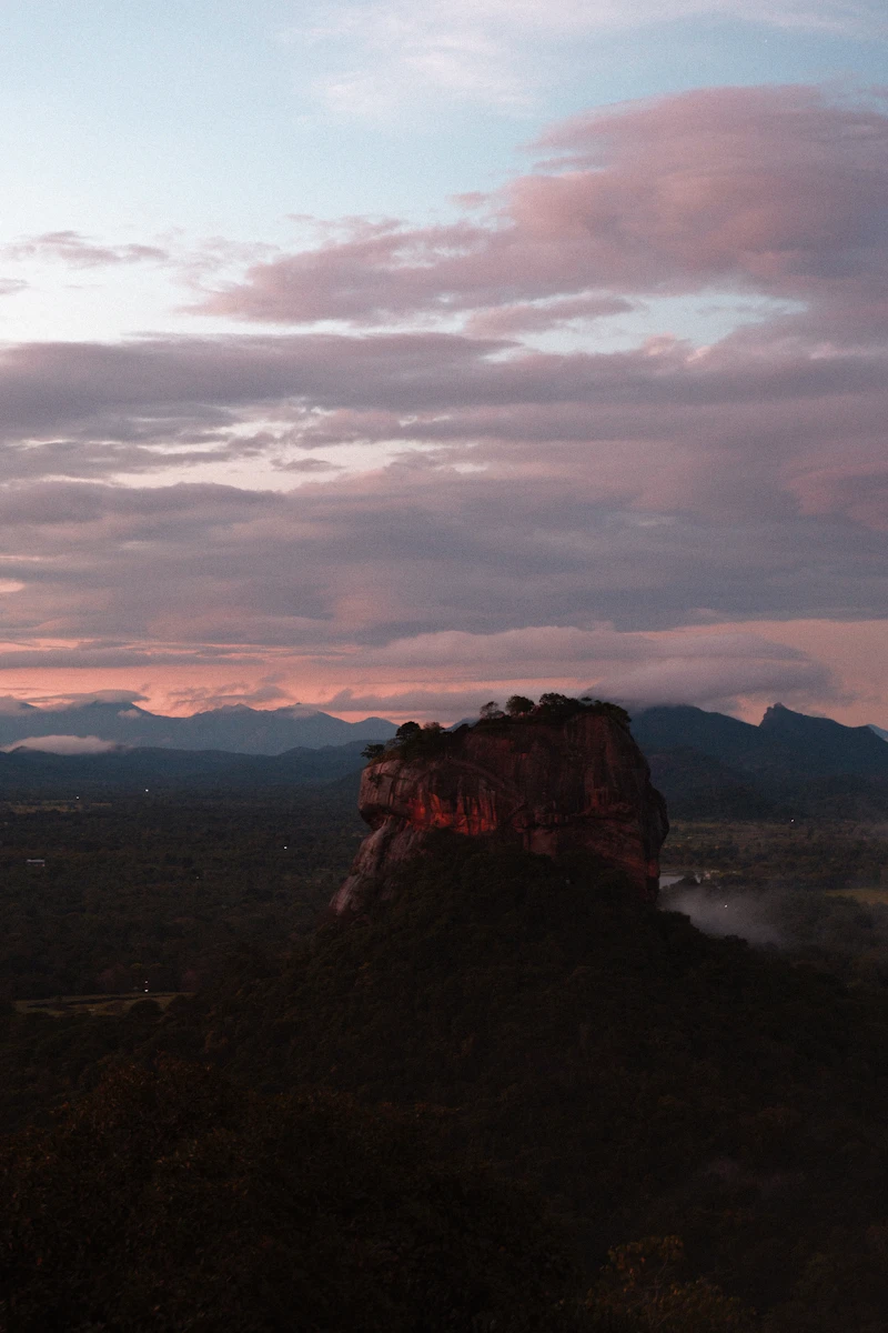 Sigiriya Lion Rock at sunrise under pink clouds