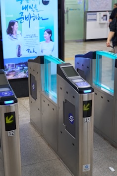 Entrance gates with illuminated blue panels in a station.