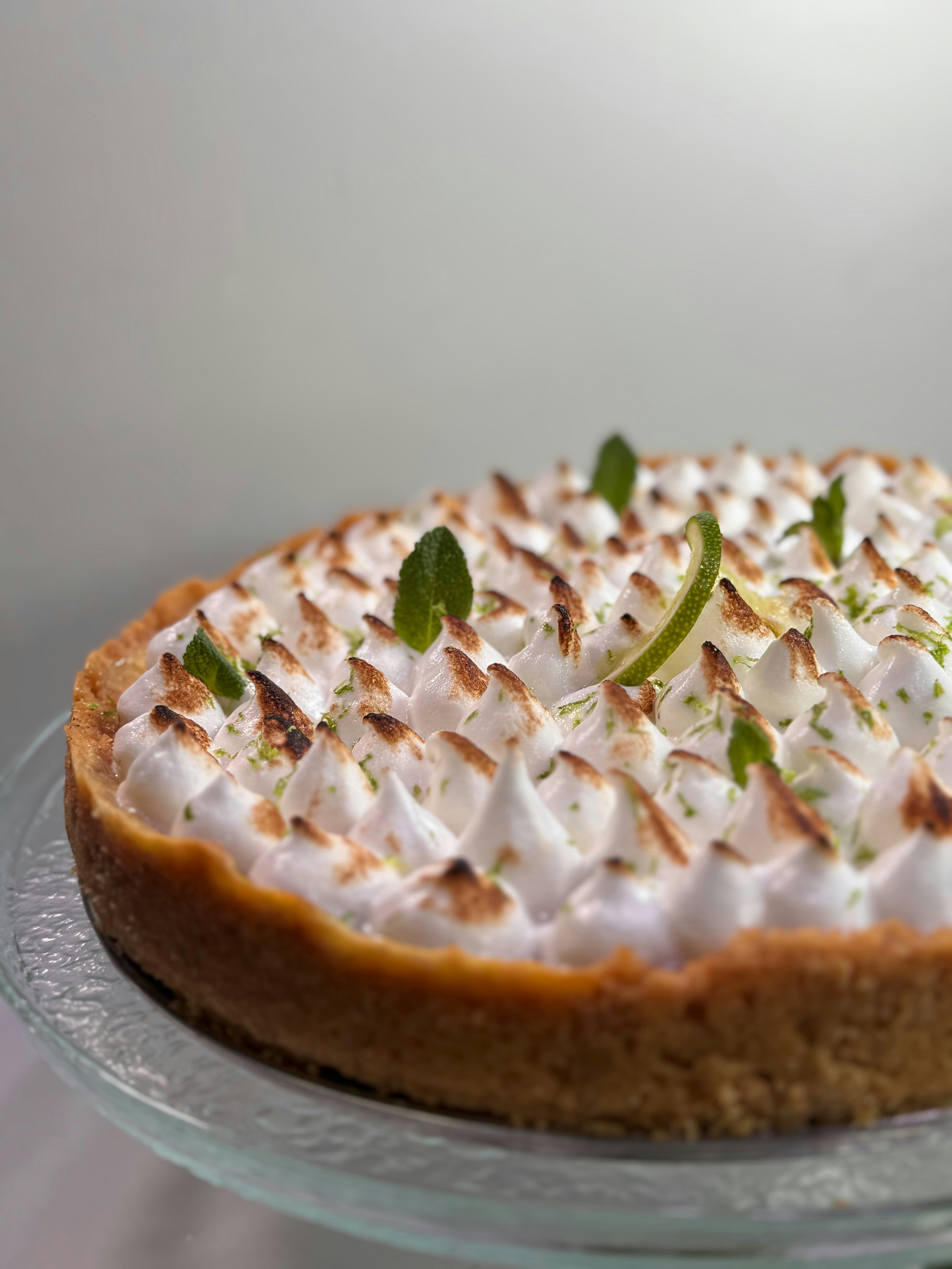 Lemon meringue pie with toasted peaks and mint garnish