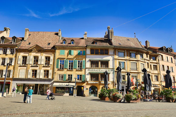 Buildings lining a european town square with people.