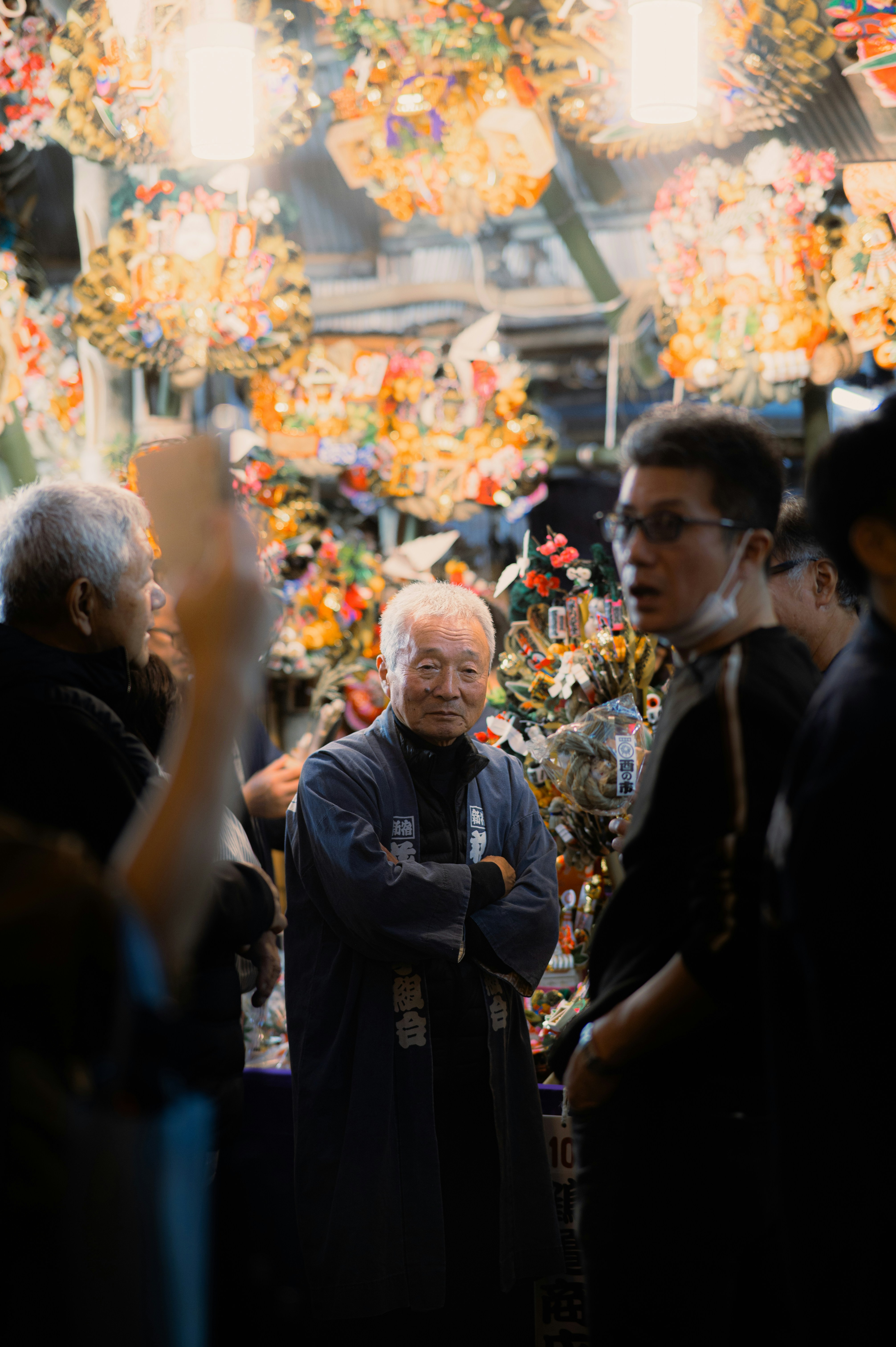 Elderly man with arms crossed among colorful decorations
