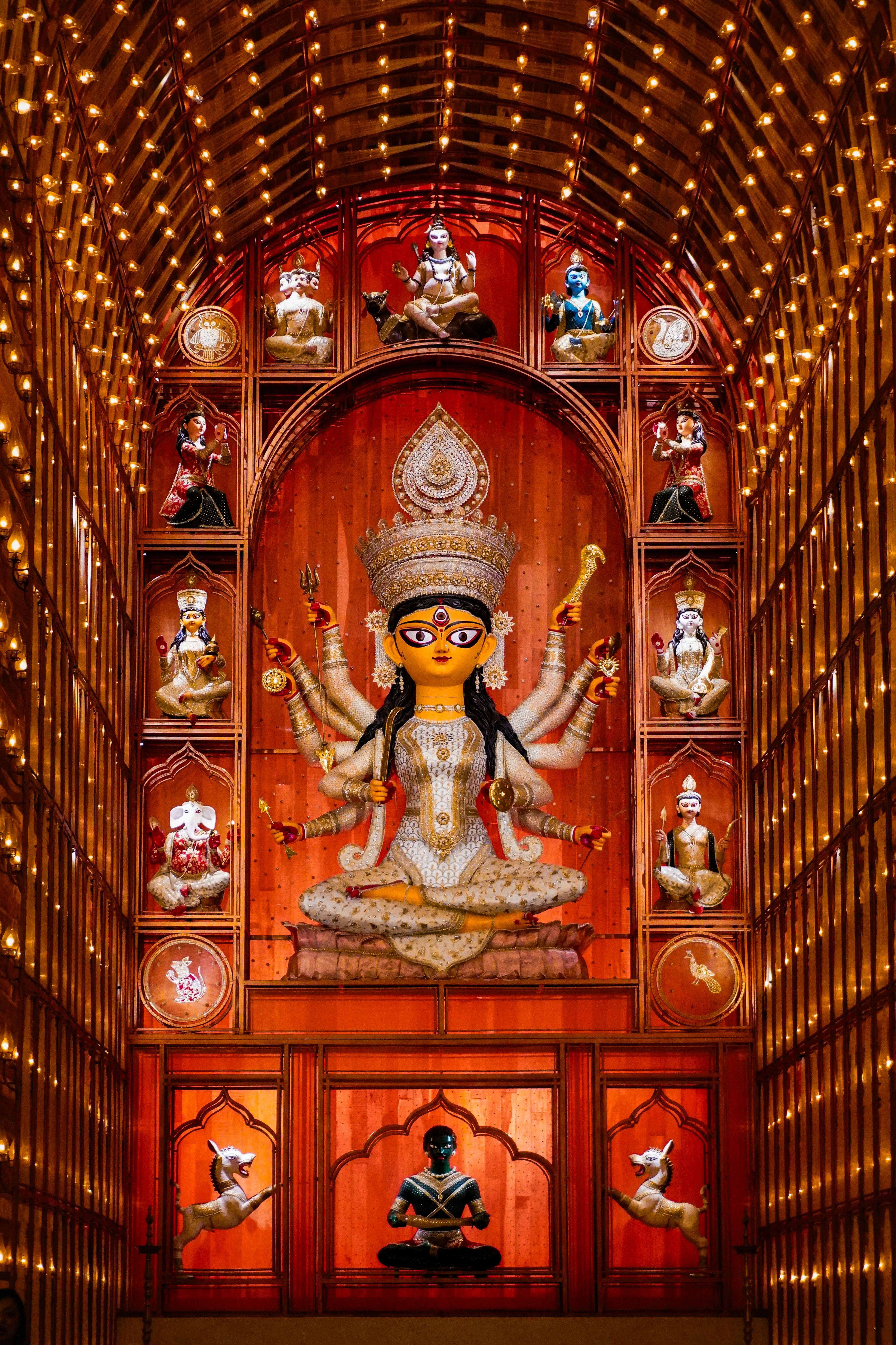 Um ídolo colorido da deusa hindu cercado por divindades menores.