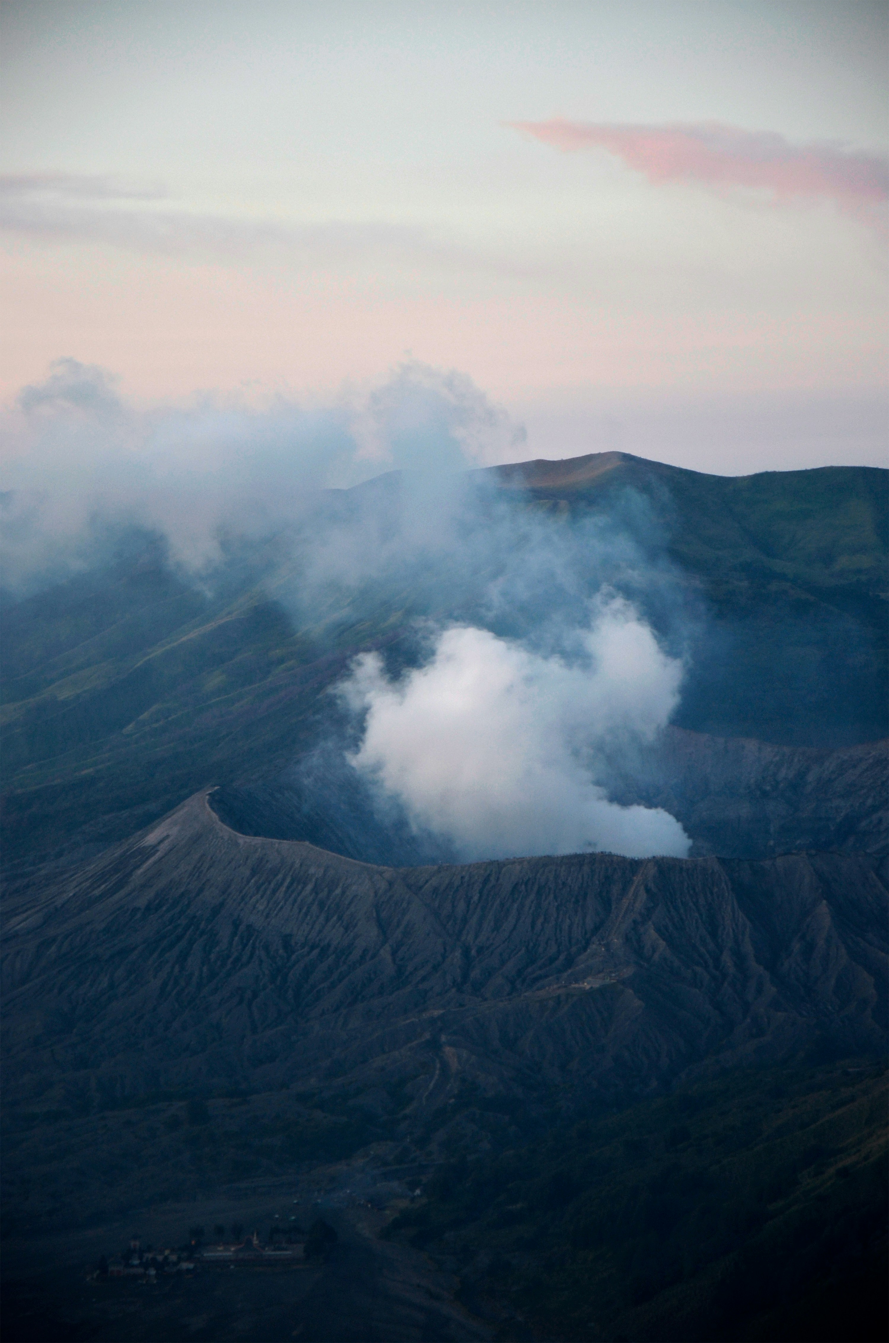 Volcano emitting smoke against a pastel sky