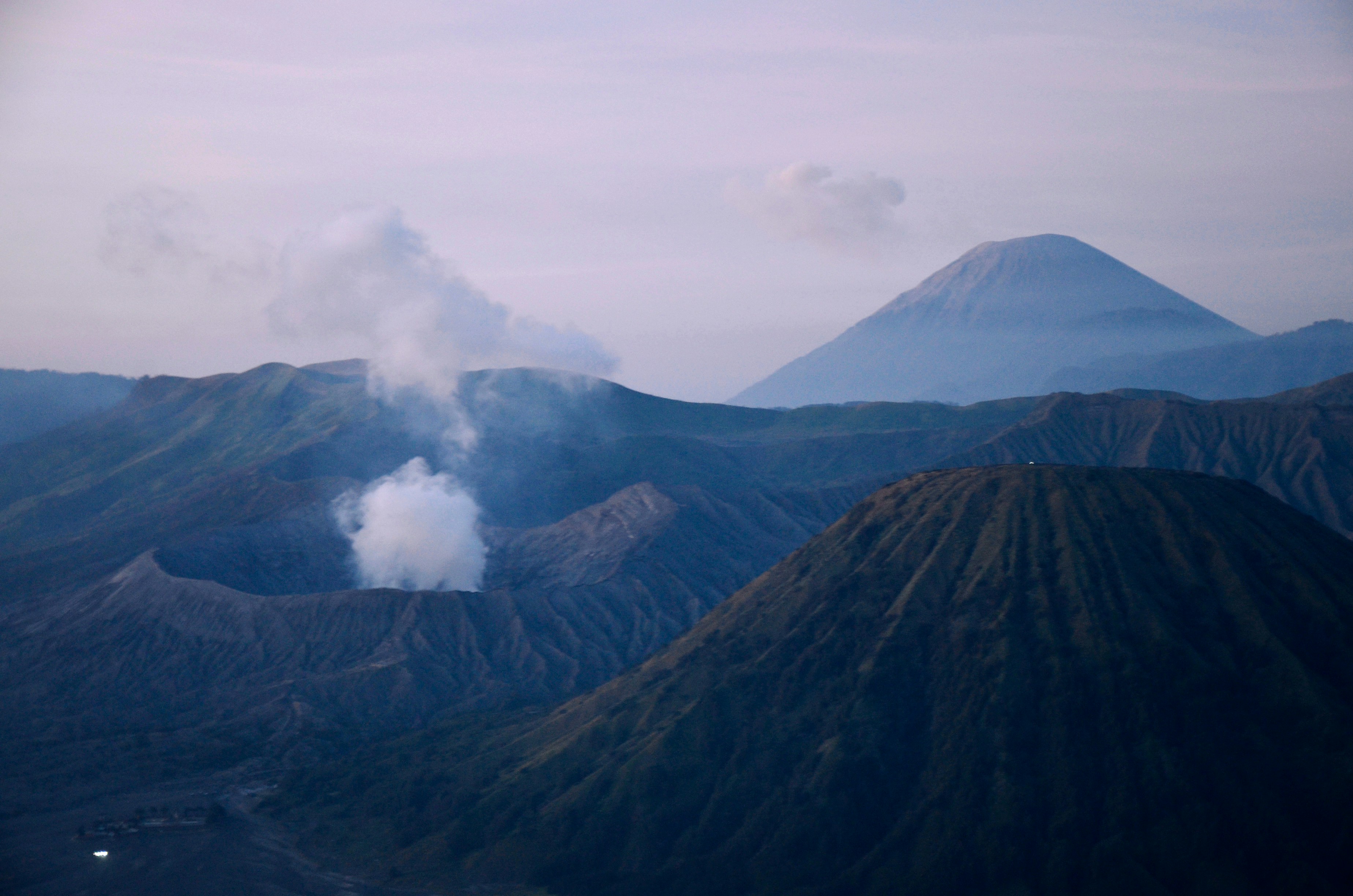 Volcanic landscape with smoking craters and distant peak