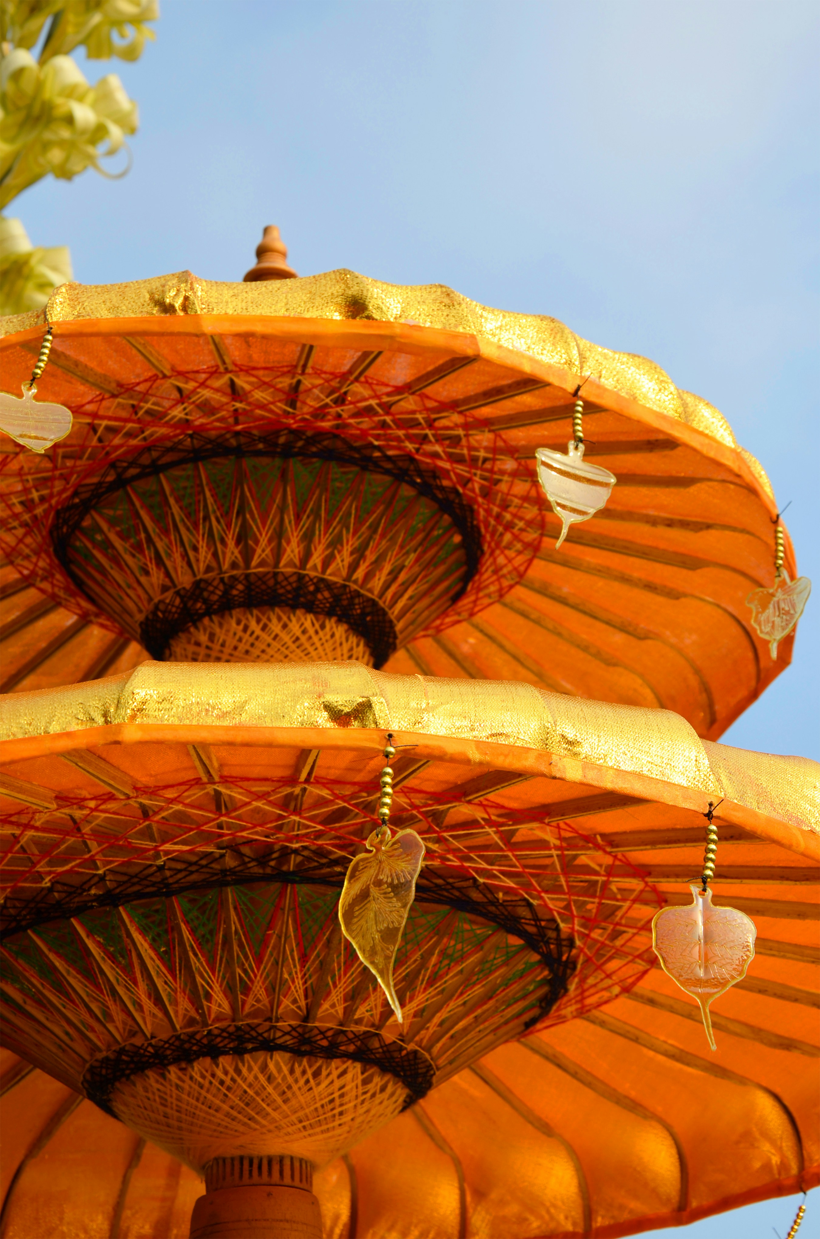 Two ornate orange umbrellas against a blue sky