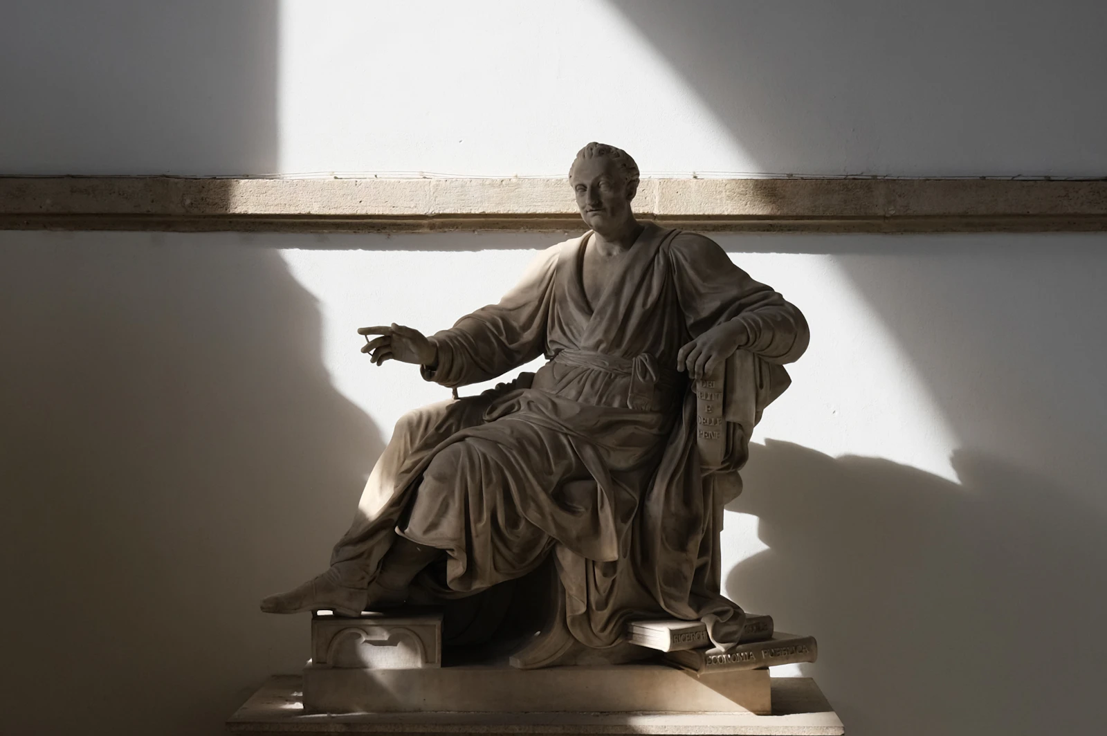 Classical marble figure seated in raking sunlight