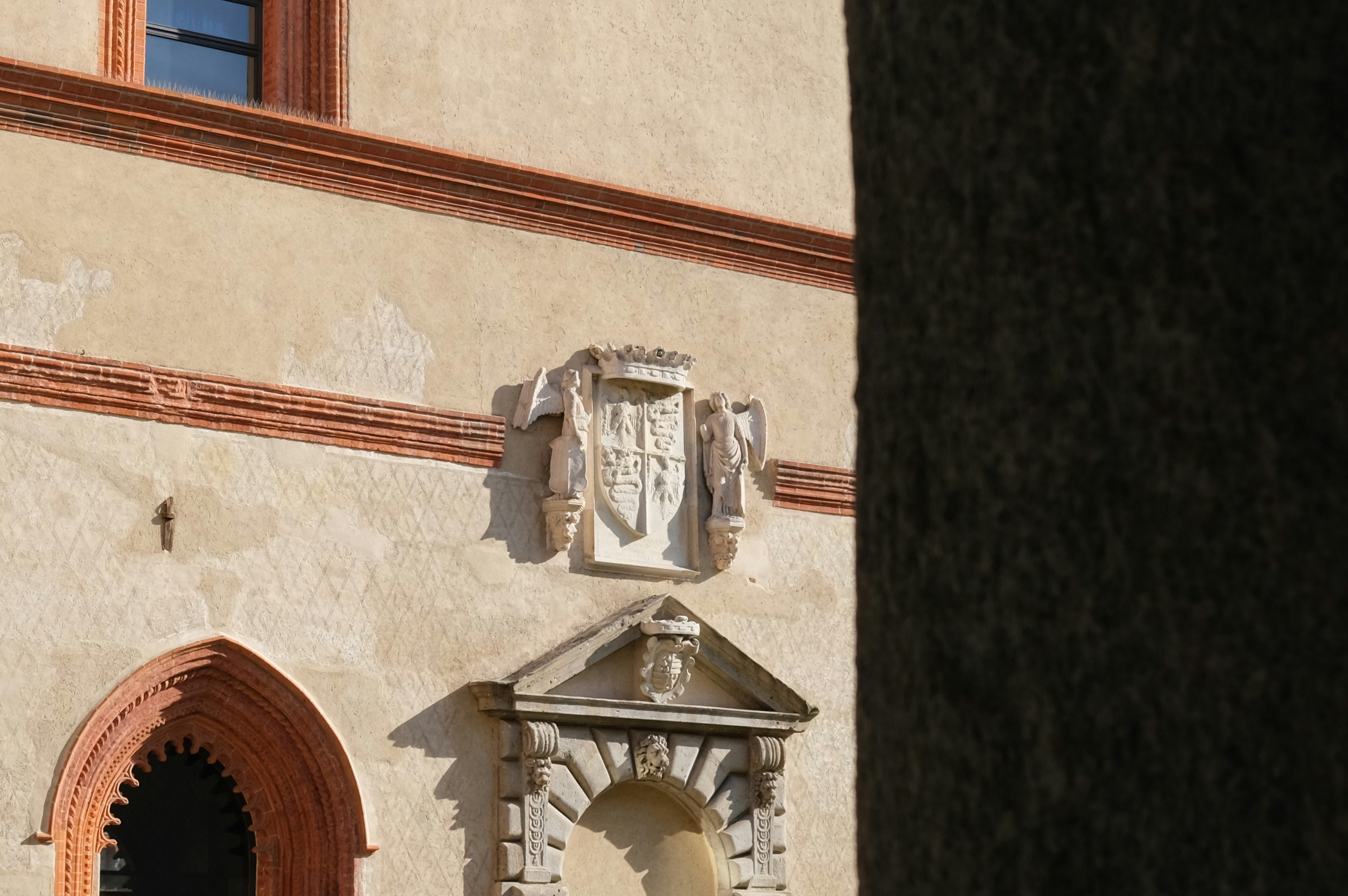Stone coat of arms above an arched doorway