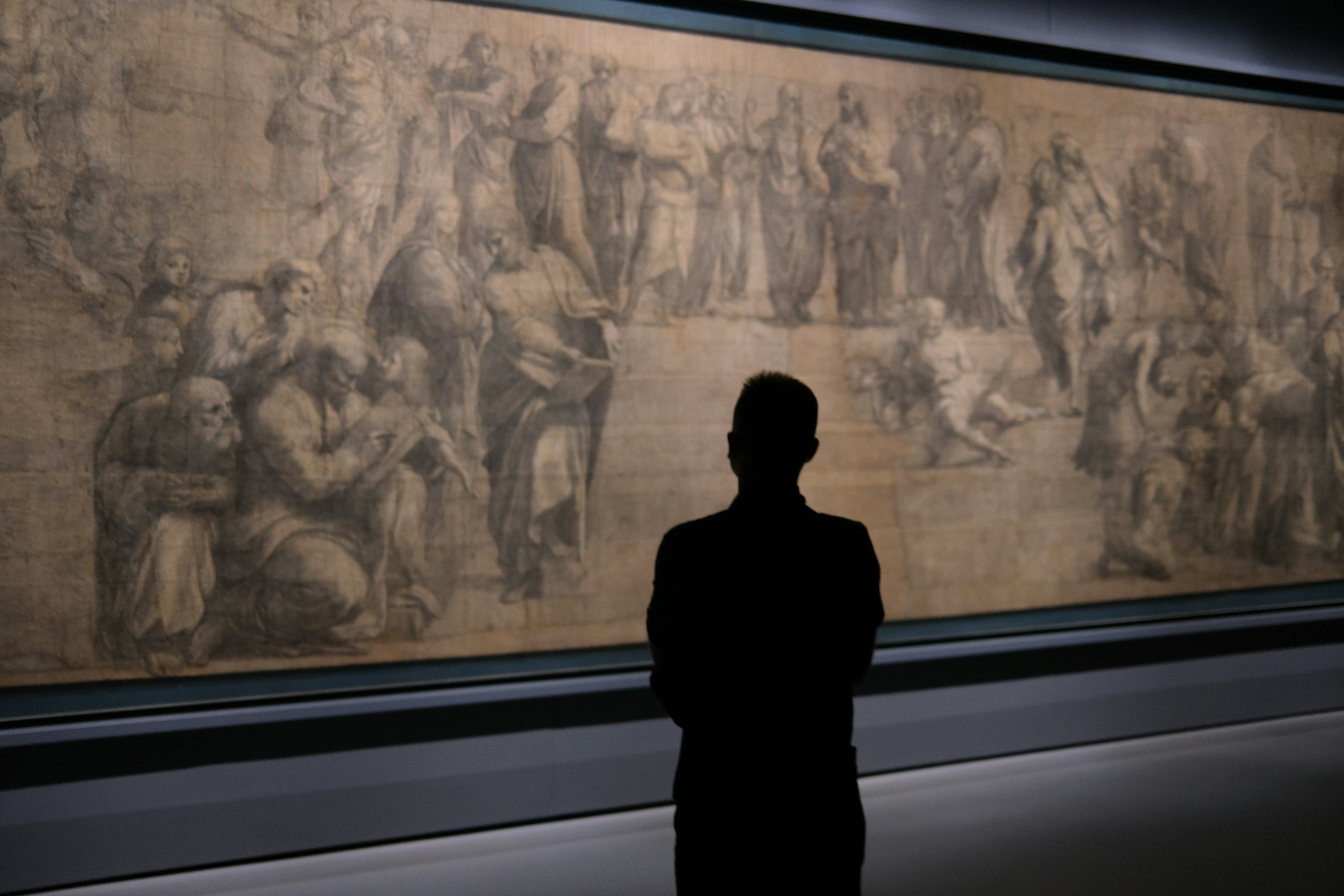 Man looking at a large historical drawing