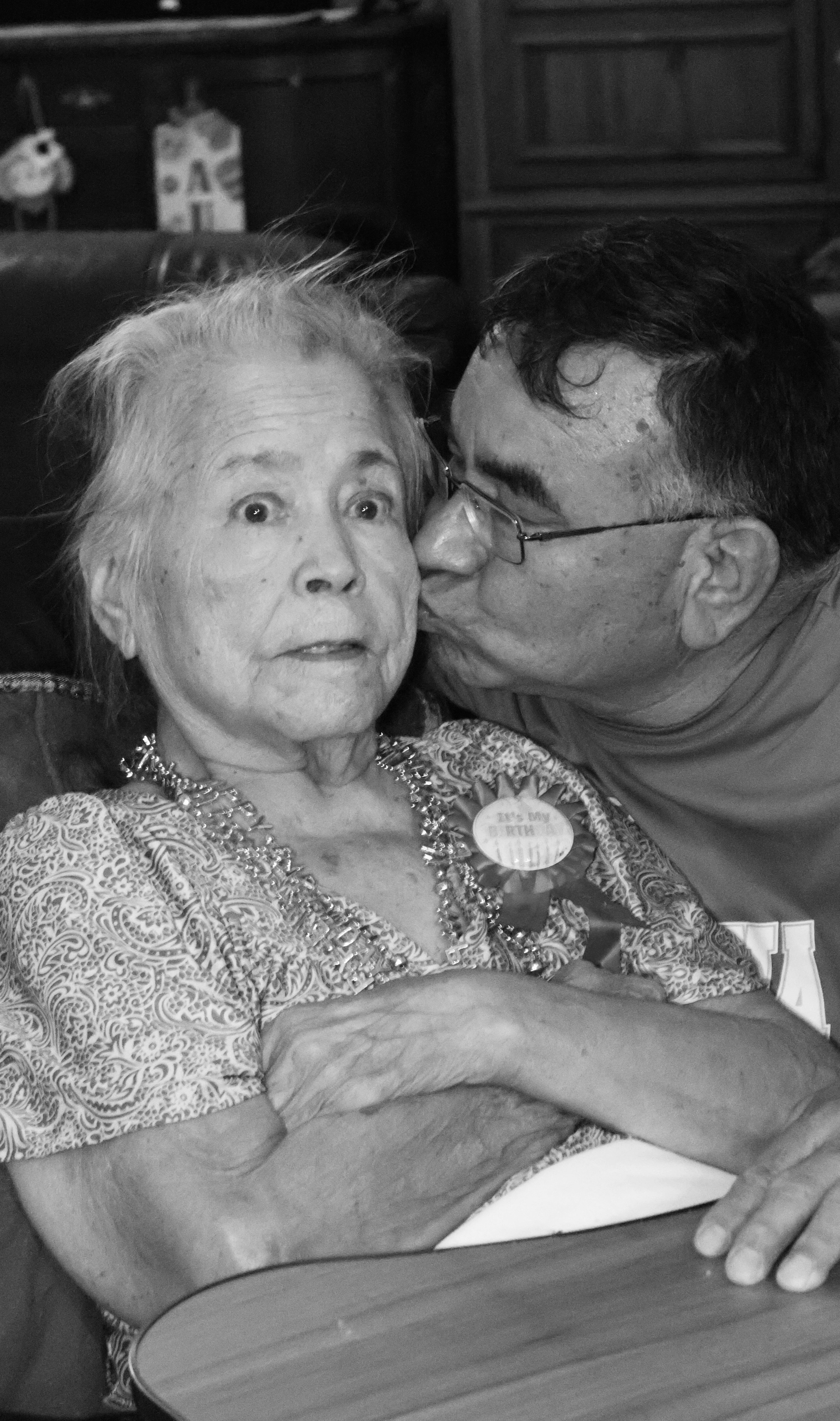 Man kisses an elderly woman on the cheek
