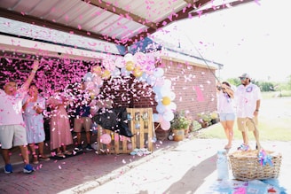 People celebrating with pink confetti and balloons