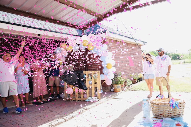 People celebrating with pink confetti and balloons