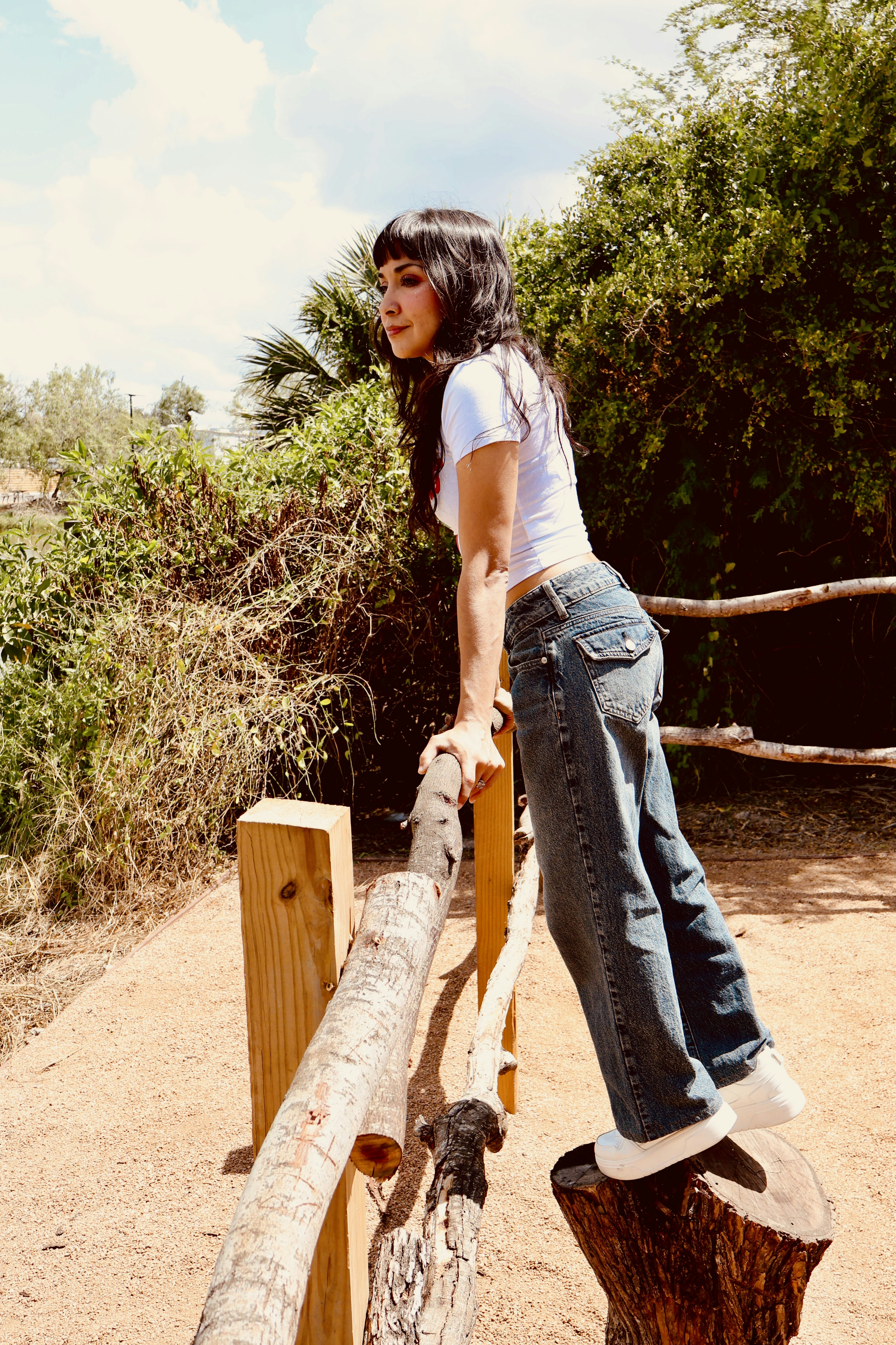 Woman leaning on wooden fence outdoors