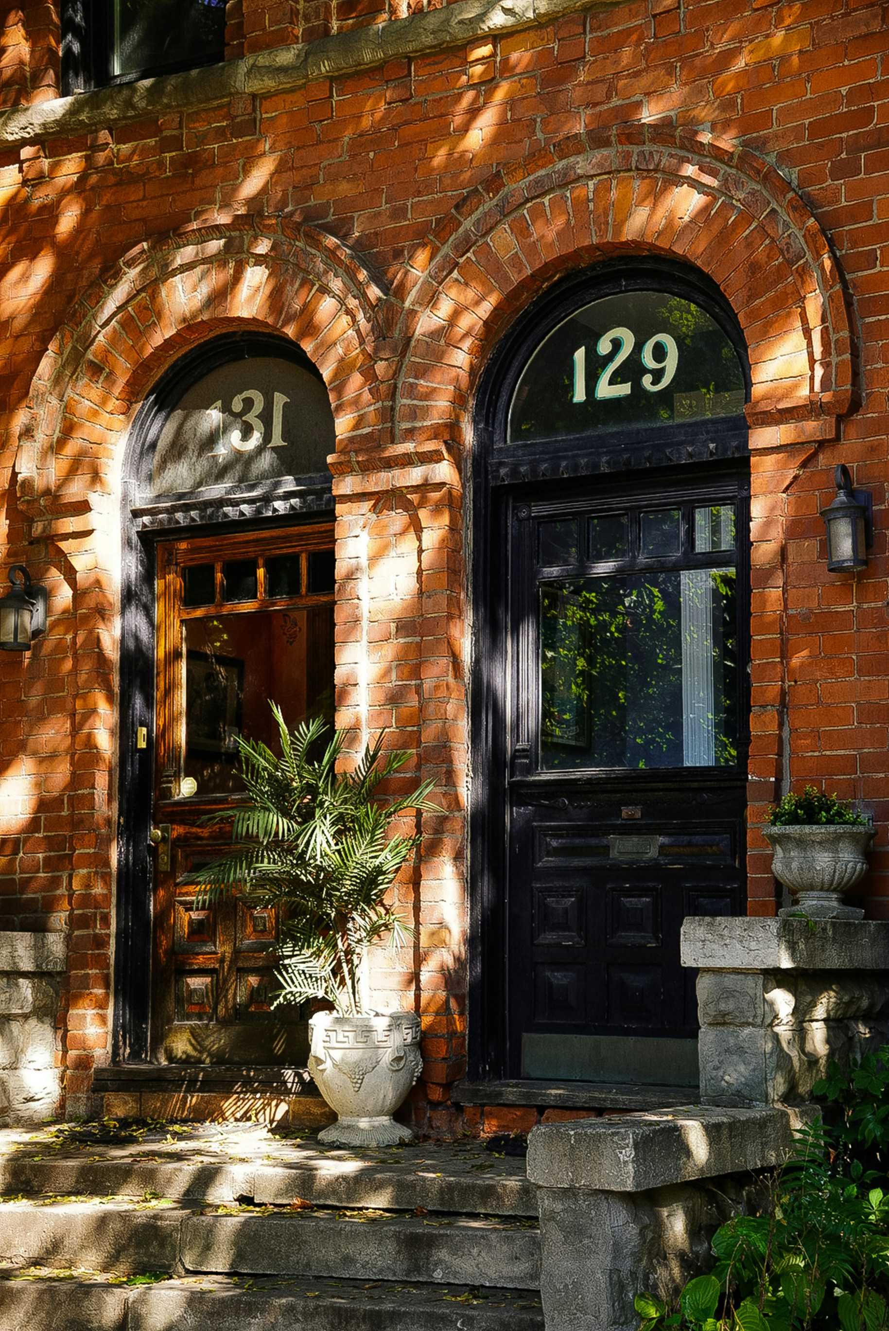 Two brick row house doors with numbers 31 and 129.
