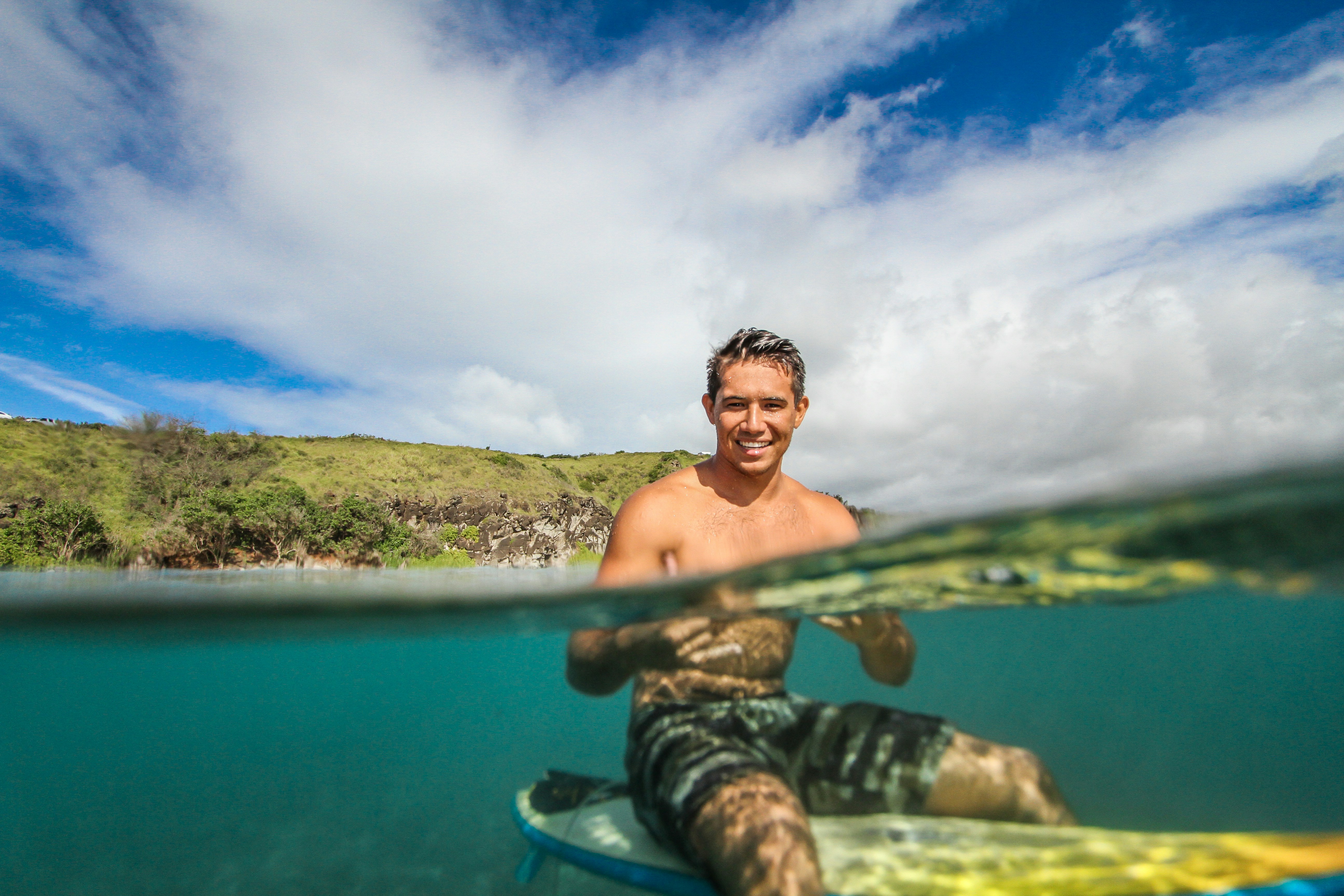 A surfer in clear Hawaiian water, the laid-back spirit the shaka stands for