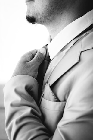 Man adjusting his suit collar and tie