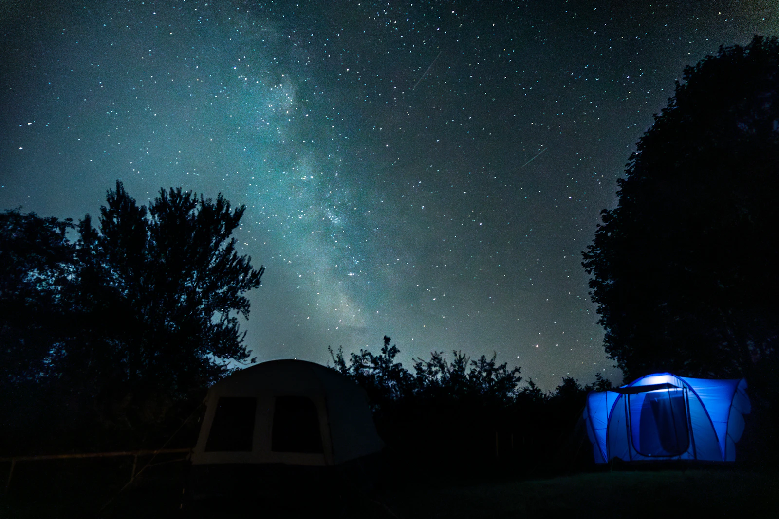 Two tents pitched beneath the sweeping arc of the Milky Way over the open prairie