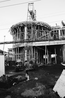 Construction of a large circular building with scaffolding.