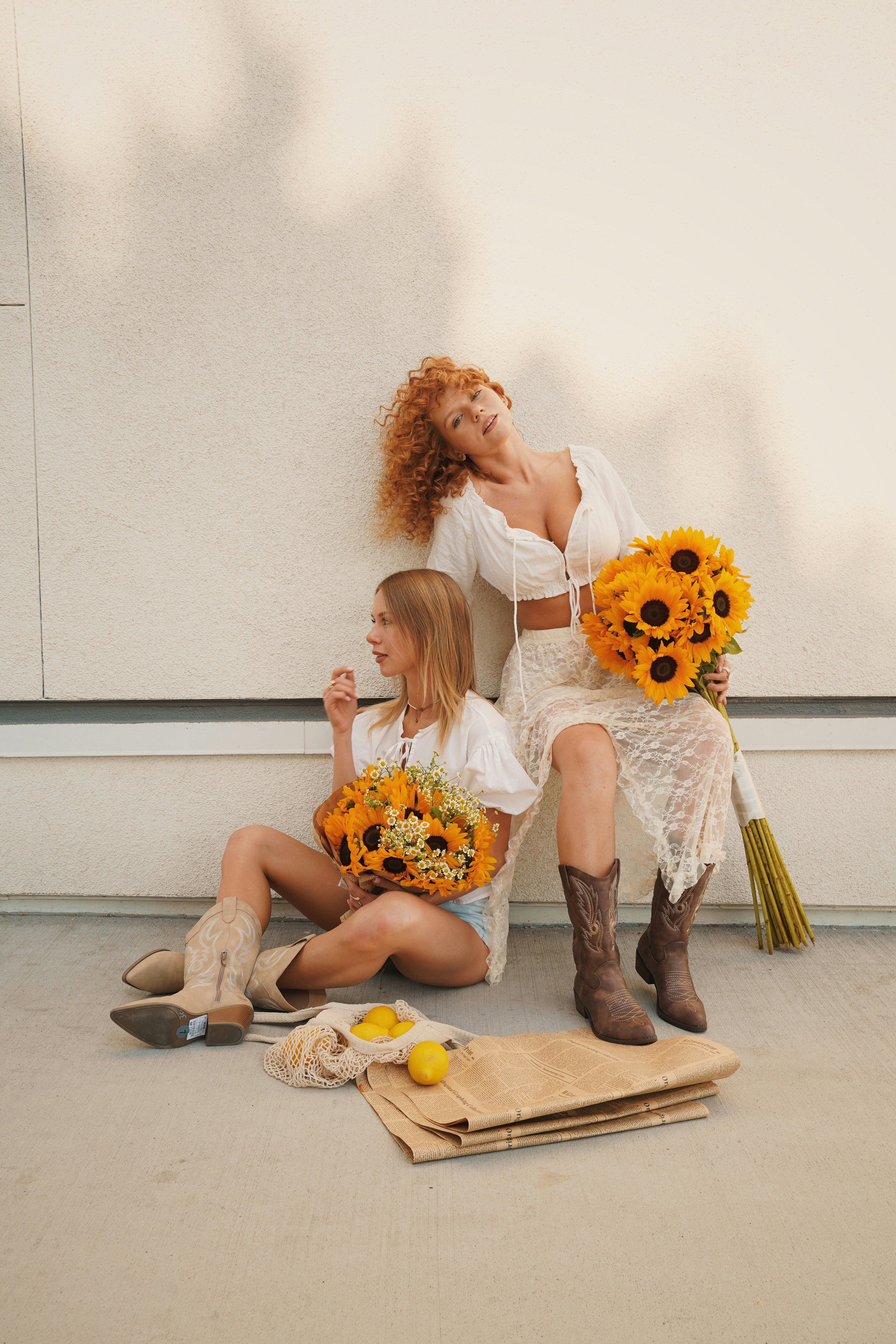 Zwei Frauen mit Sonnenblumen und Zitronen