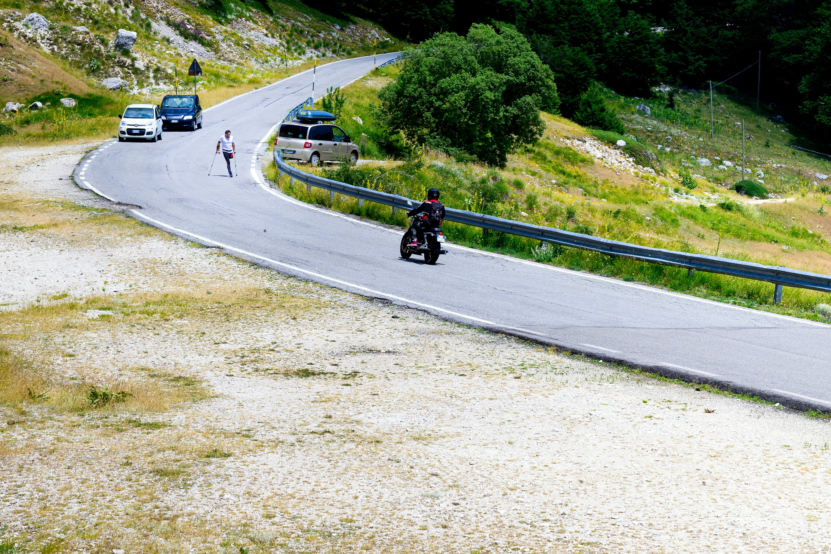 Motorcyclist and cars on a winding mountain road