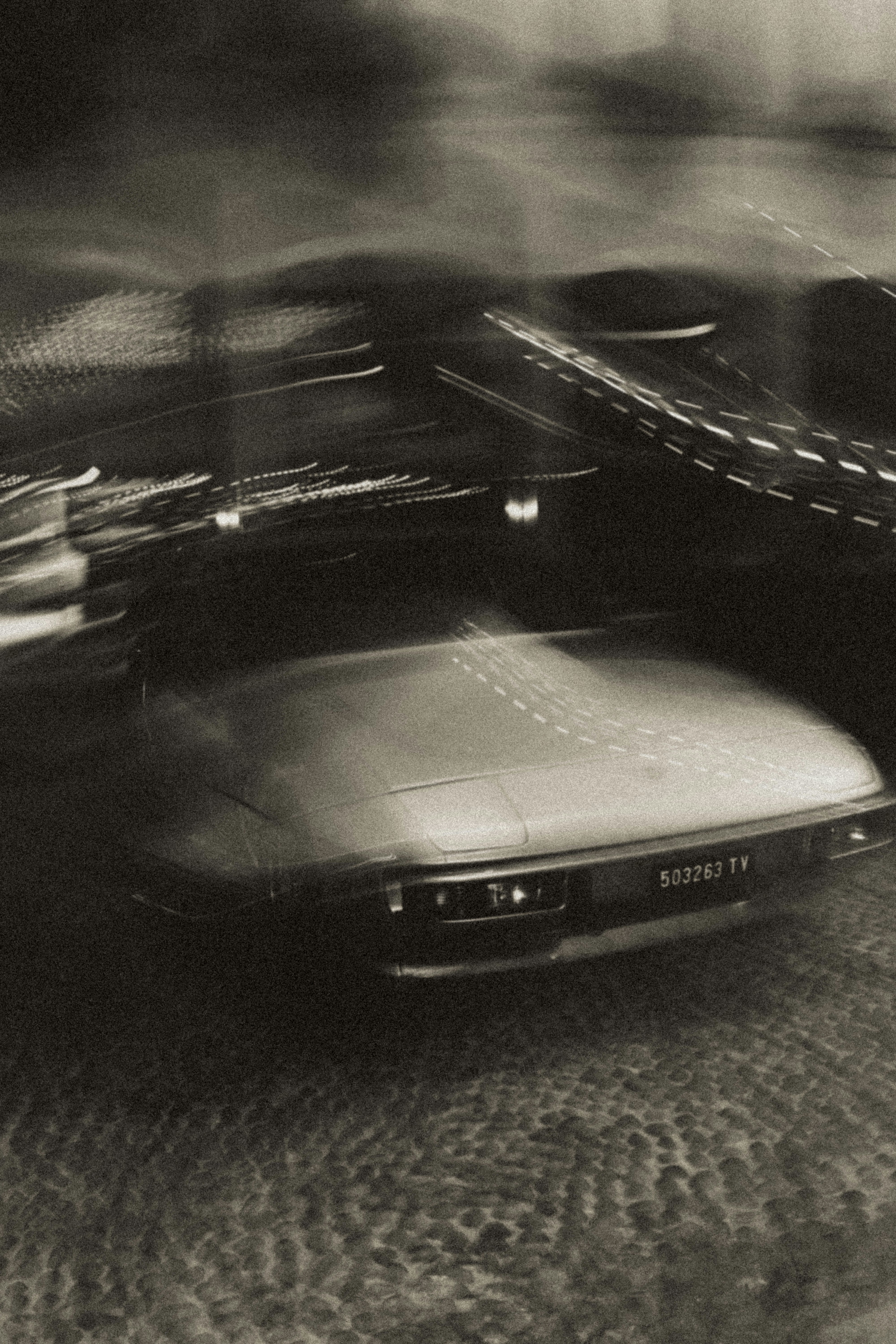 Luci sfocate dell'auto di notte con un'auto d'epoca.
