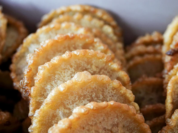 Close-up of golden fried pastries with scalloped edges