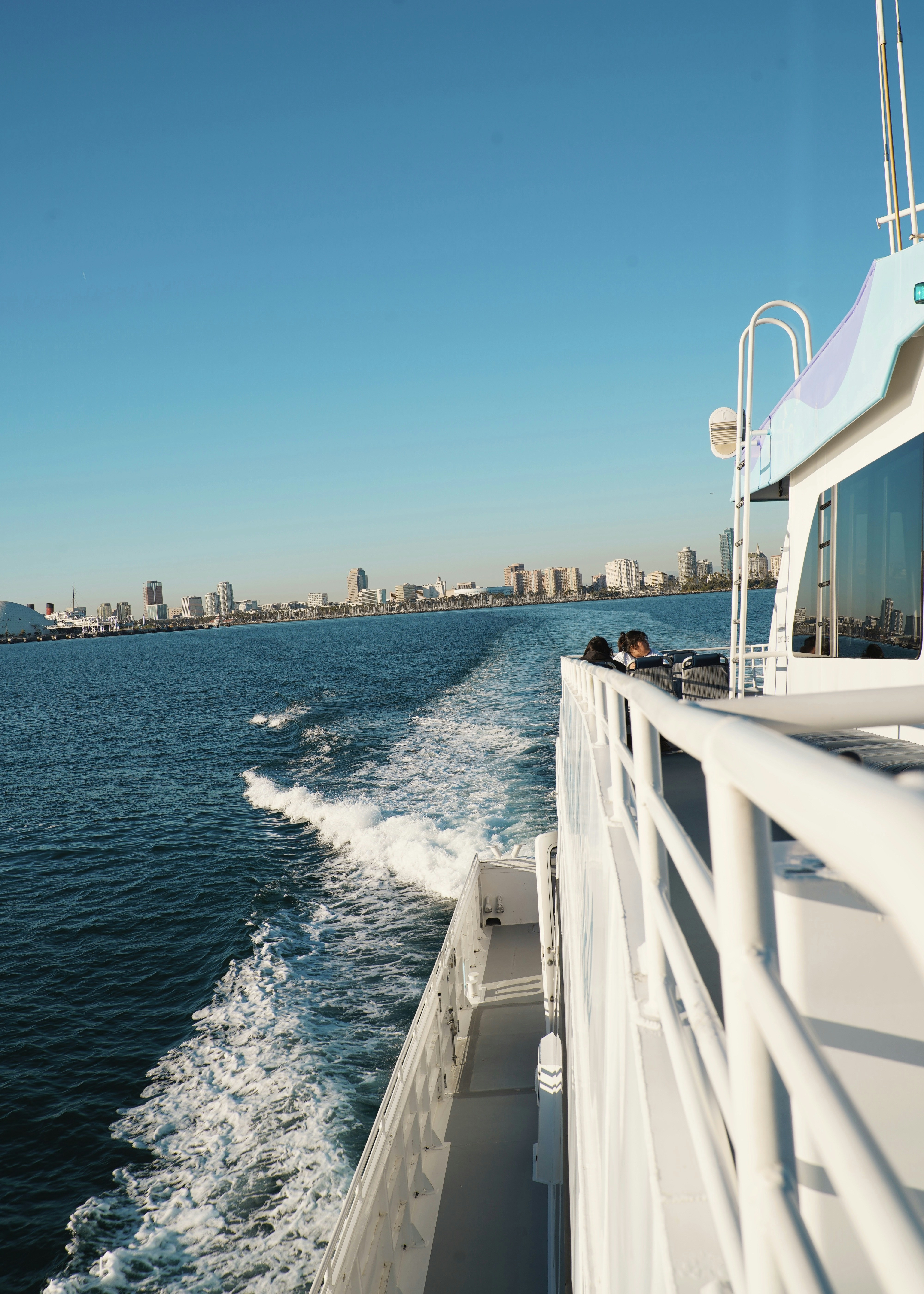 Boot segelt auf dem Ozean in Richtung der Skyline der Stadt